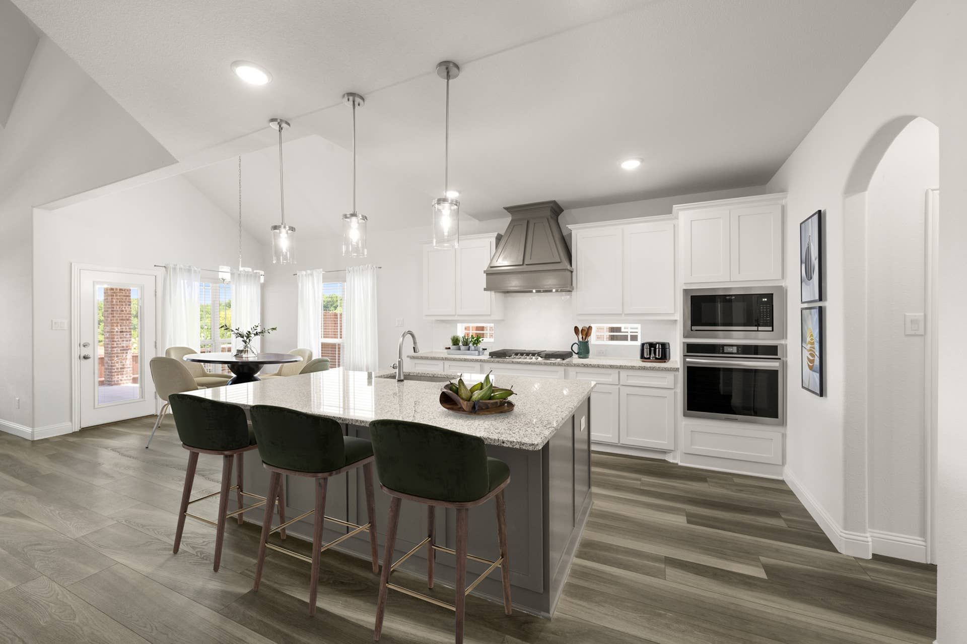 Modern kitchen with white cabinets, island seating, and pendant lighting.