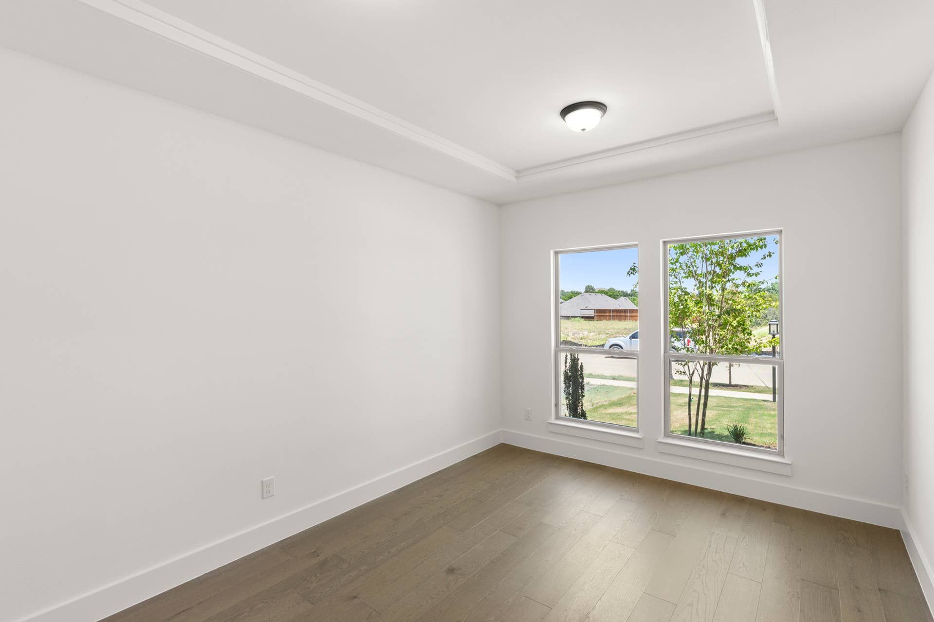 Bright dining room with large windows and hardwood floors.