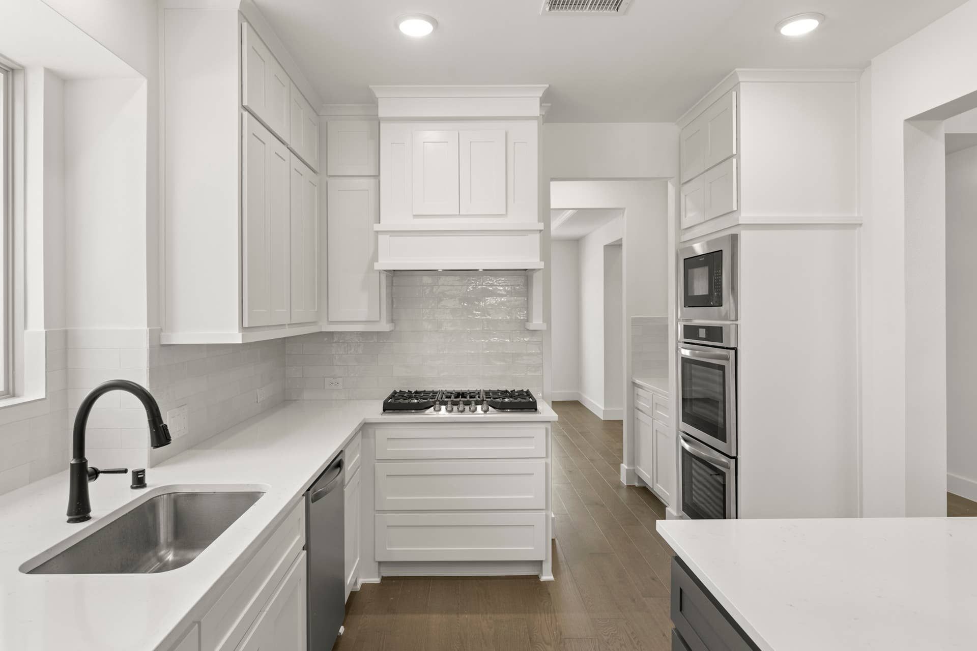 Modern white kitchen with sleek cabinetry and stainless steel appliances.