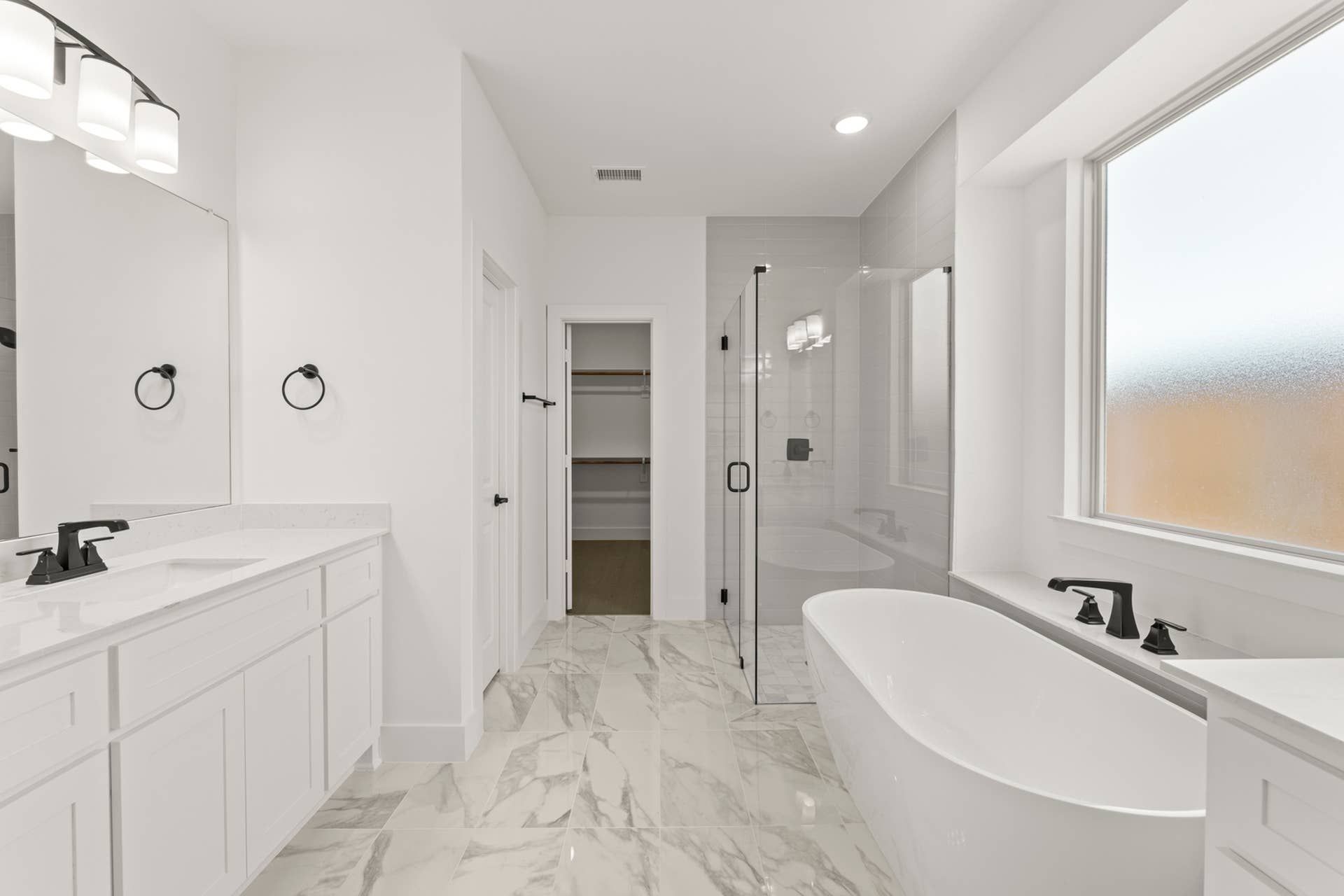 Luxurious modern bathroom with freestanding tub and glass-enclosed shower.