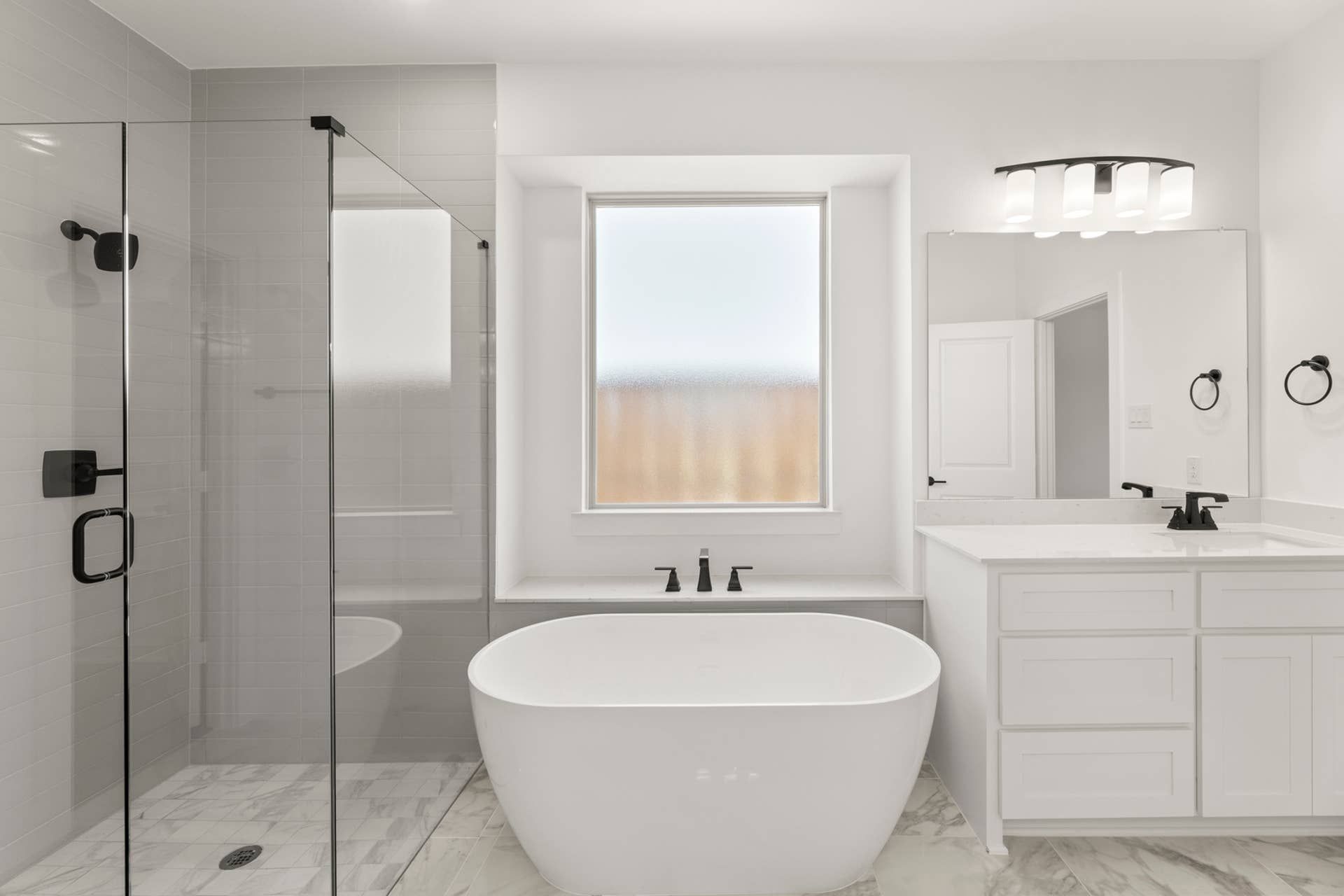 Elegant modern bathroom with freestanding tub and glass shower enclosure.