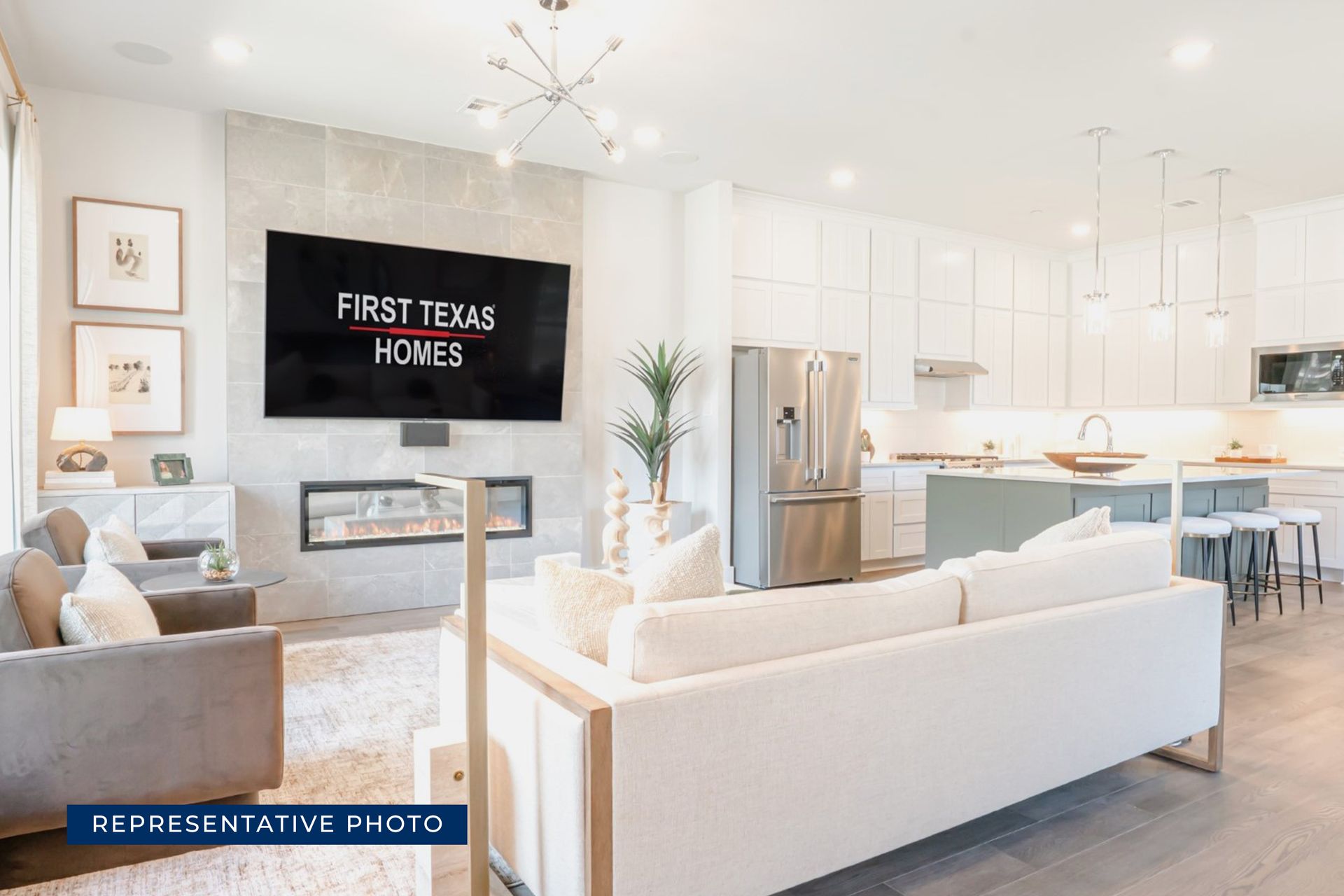 Modern open-concept living room and kitchen with sleek furniture and fireplace.