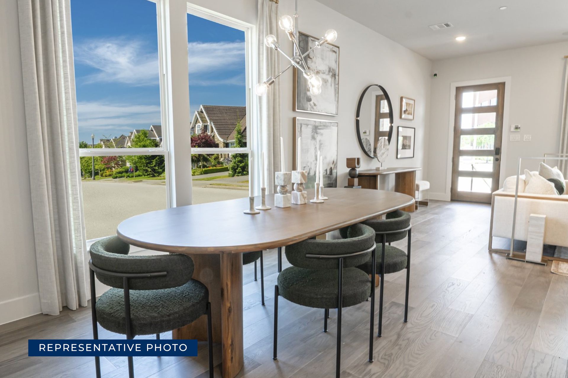 Modern dining room with wooden table and large window view.