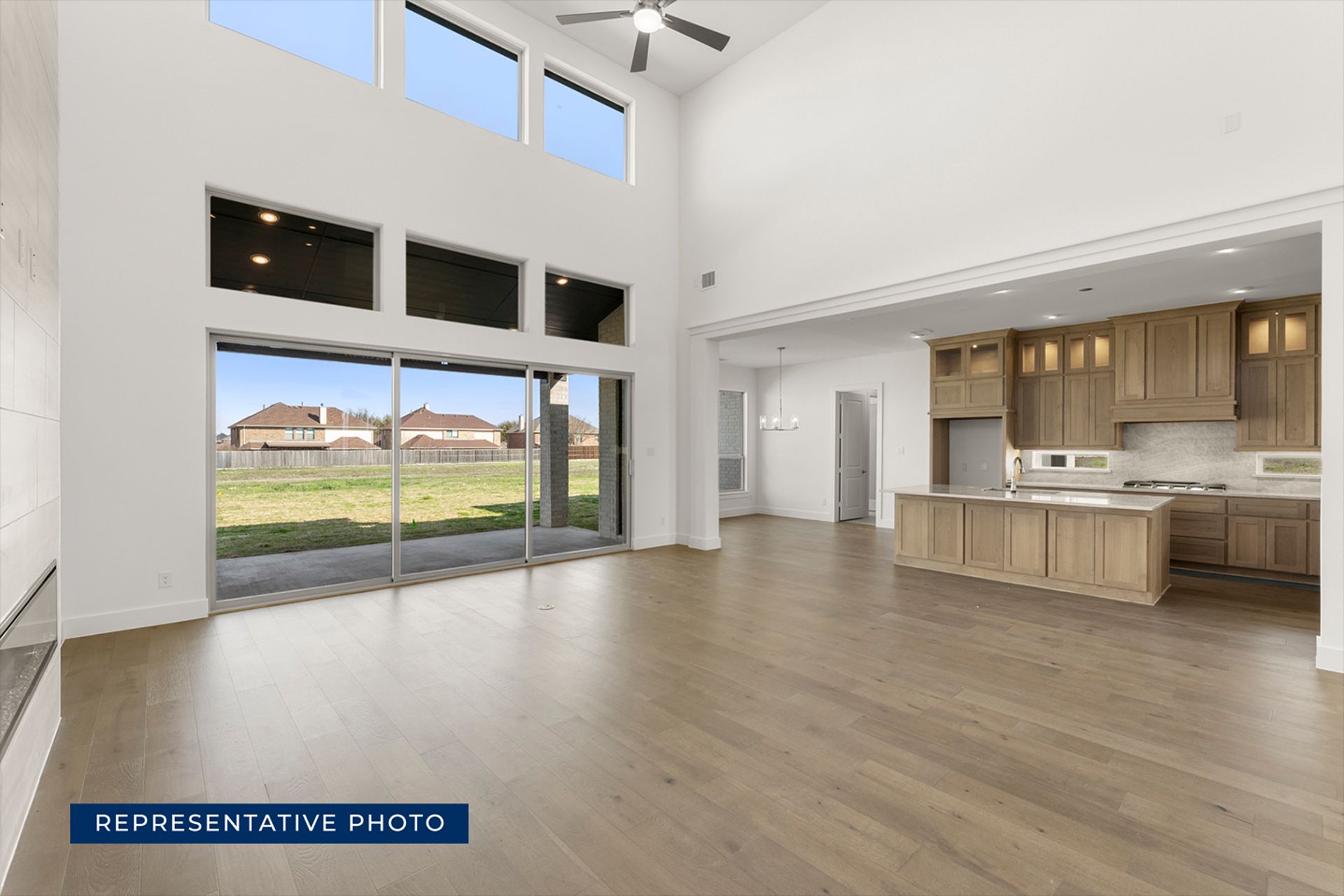 Spacious open-concept living area with large windows and modern kitchen.