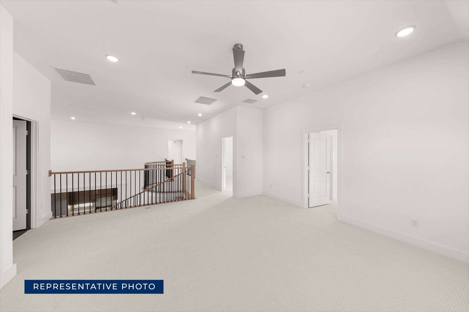 Spacious upstairs landing with modern ceiling fan and railing.