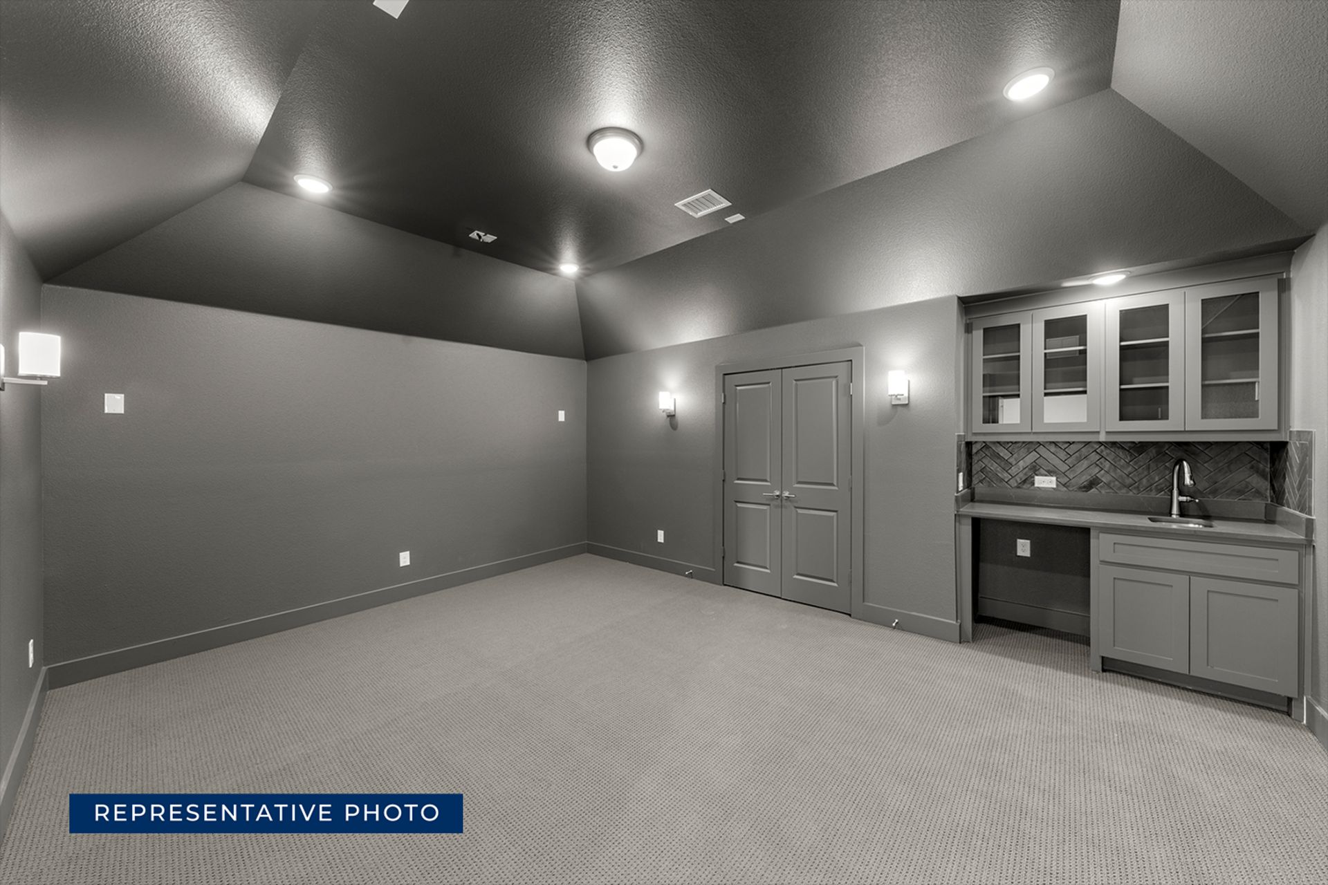 Modern gray home theater room with built-in cabinets and recessed lighting.