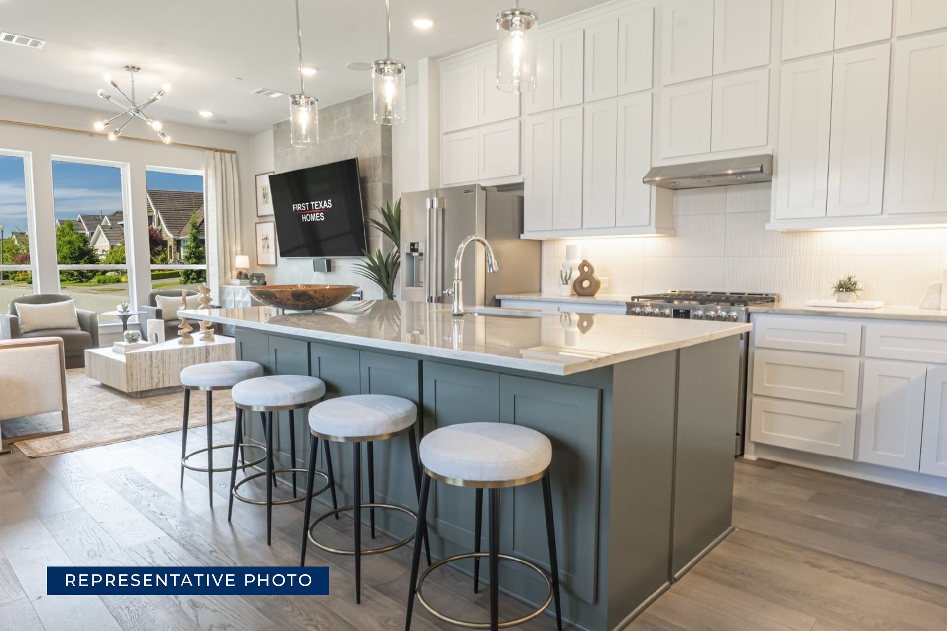 Modern kitchen and living area with island, bar stools, and large windows.