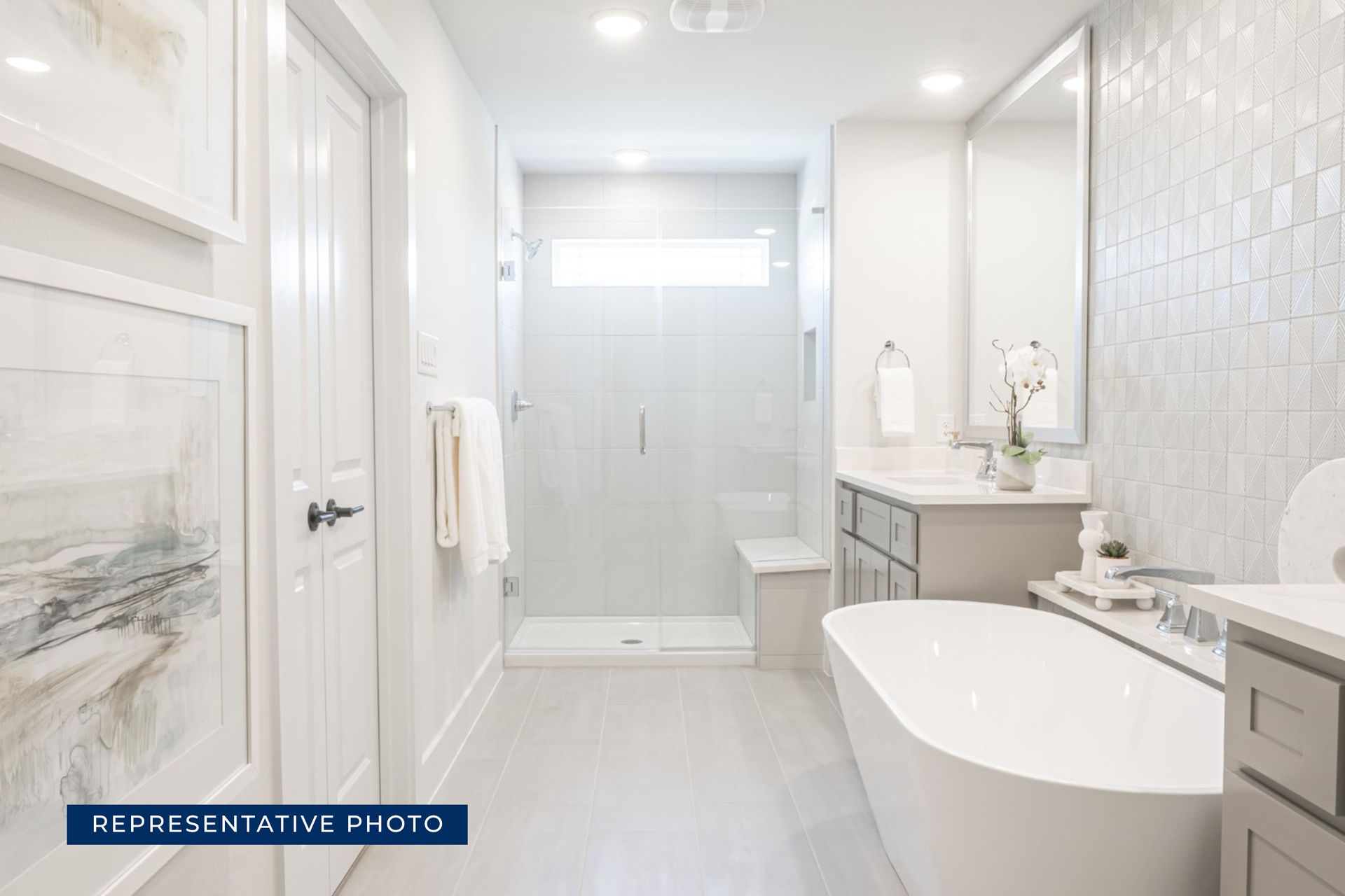 Elegant modern bathroom with freestanding tub and glass shower enclosure.
