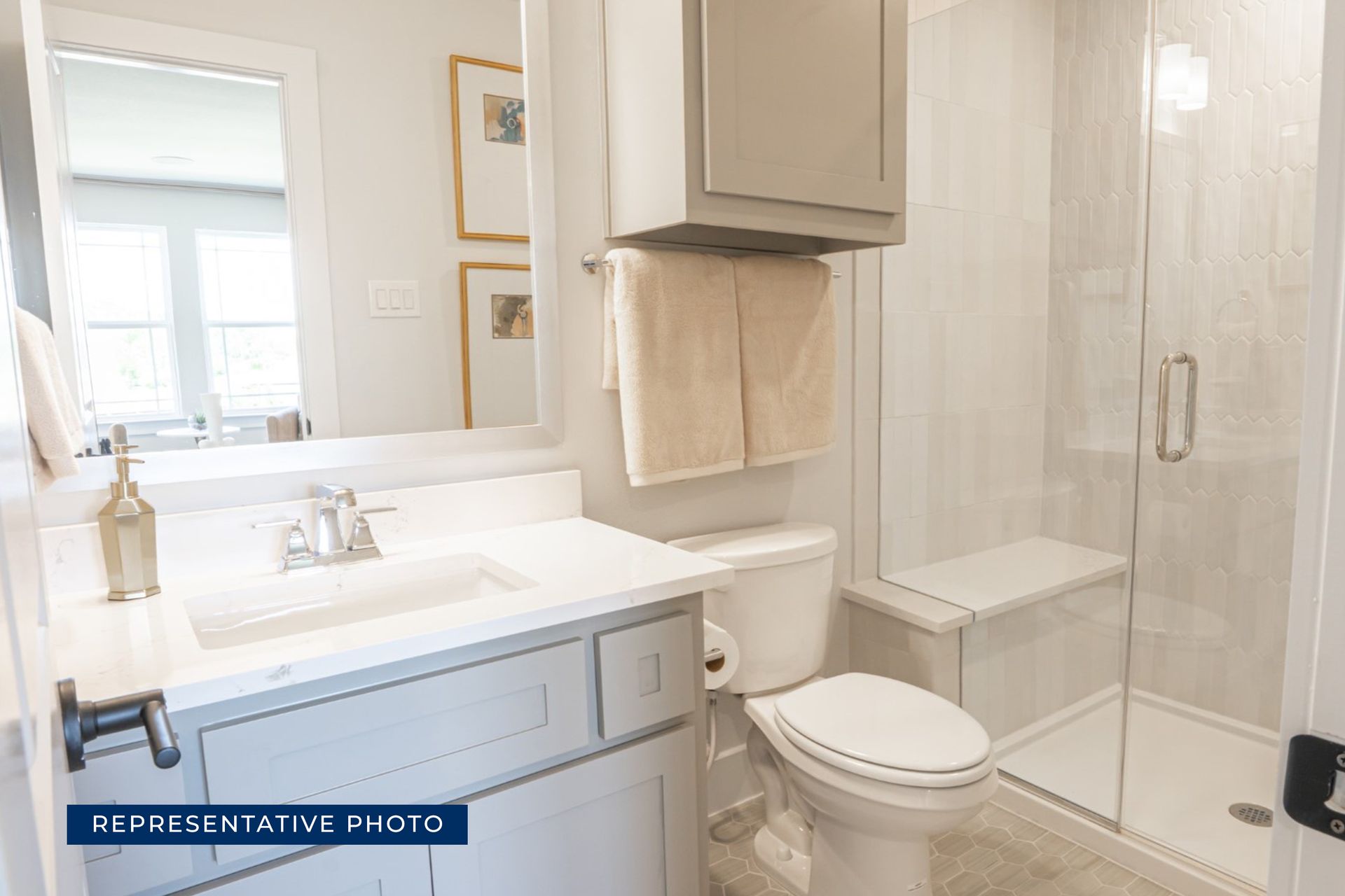 Modern bathroom with glass shower, vanity, and wall mirror.