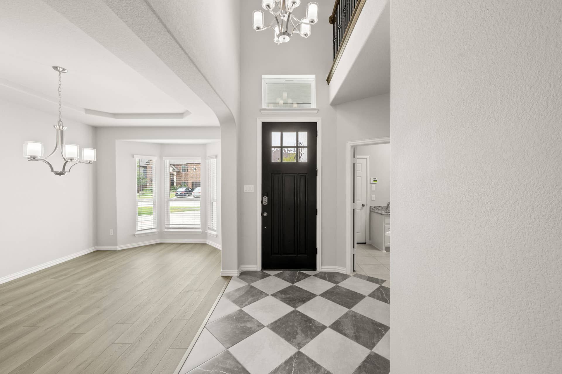Elegant entryway with black door, checkered floor, and modern chandelier.