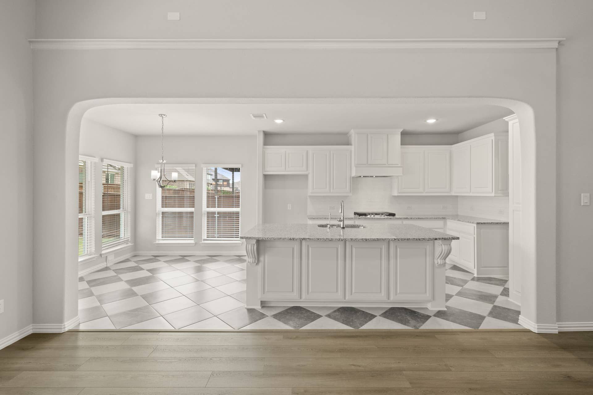 Bright kitchen with white cabinetry, granite countertops, and checkered tile flooring.