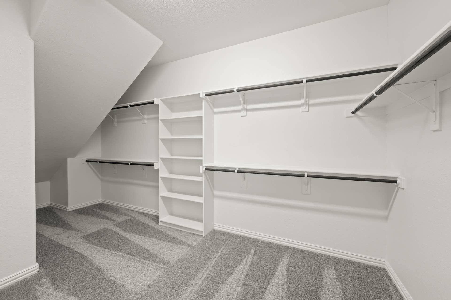 Spacious walk-in closet with shelves and hanging rods.