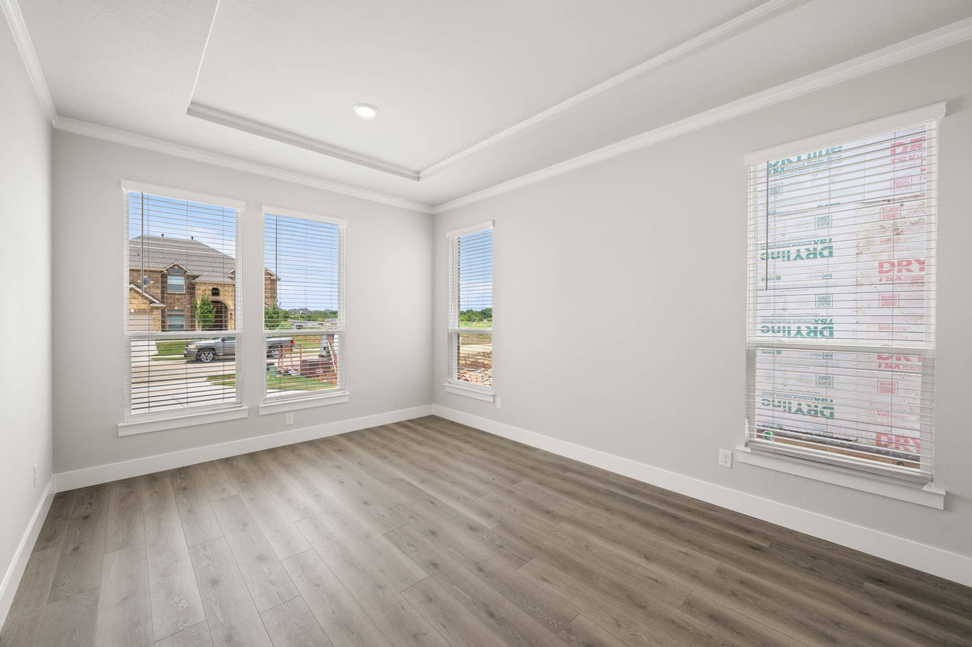 Bright dining room with large windows and wood flooring.