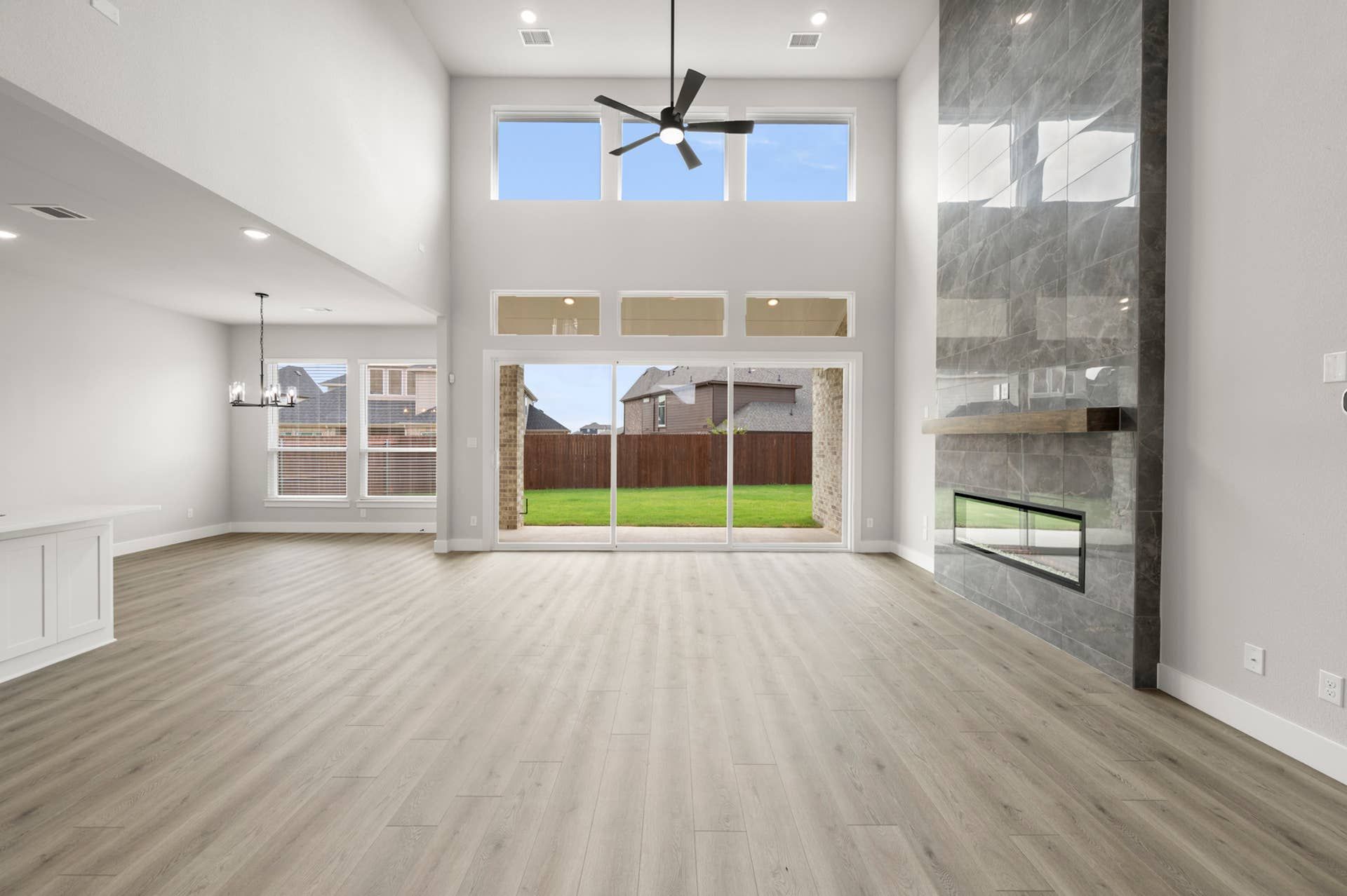 Spacious living room with high ceilings, large windows, and modern fireplace.