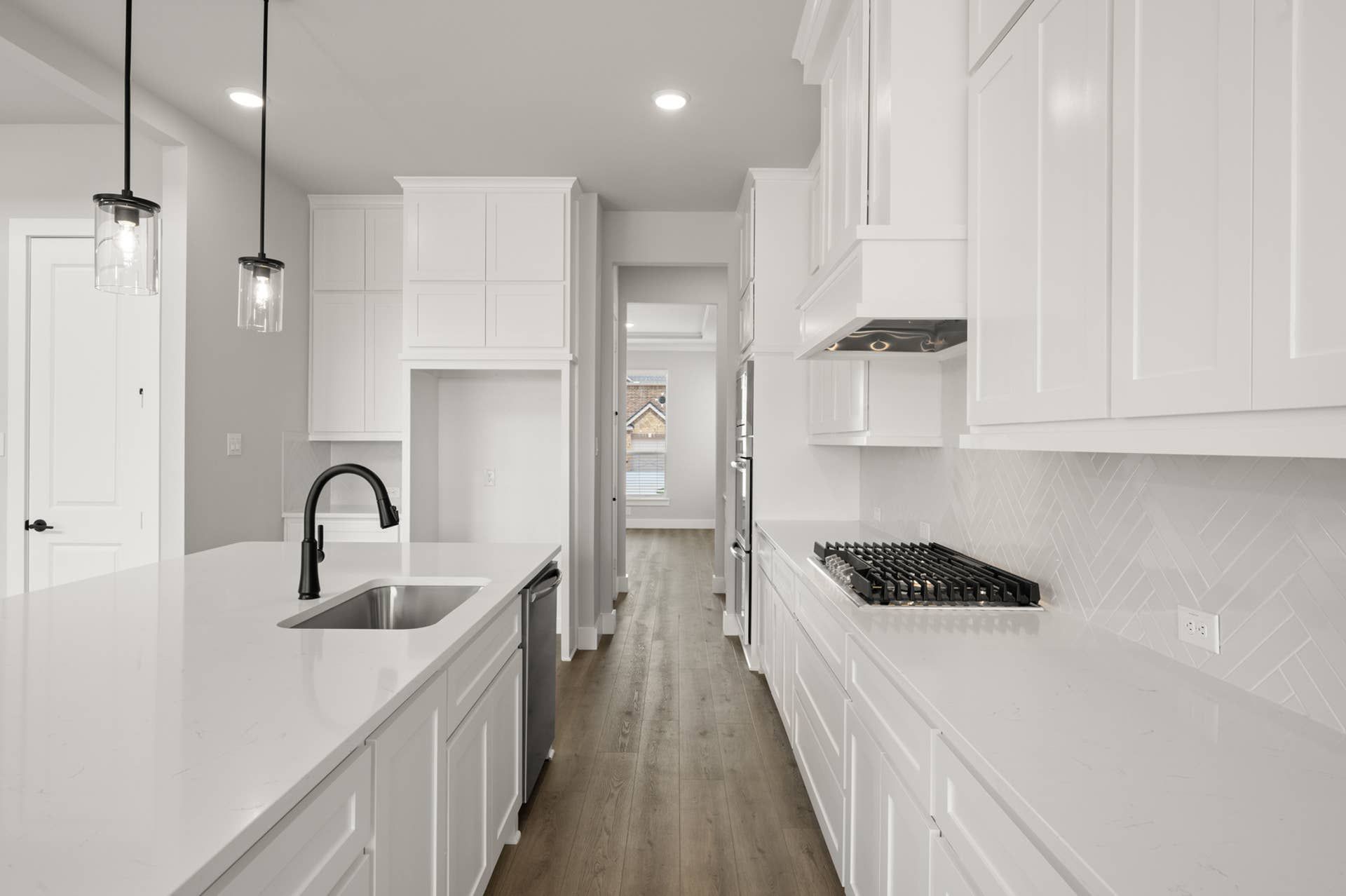 Modern kitchen with white cabinets, island sink, and gas stove.