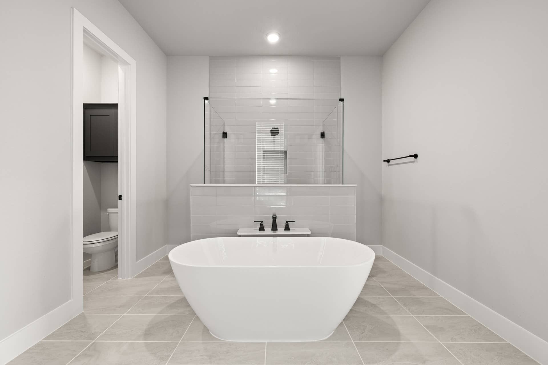 Modern bathroom with freestanding tub and glass-enclosed shower.