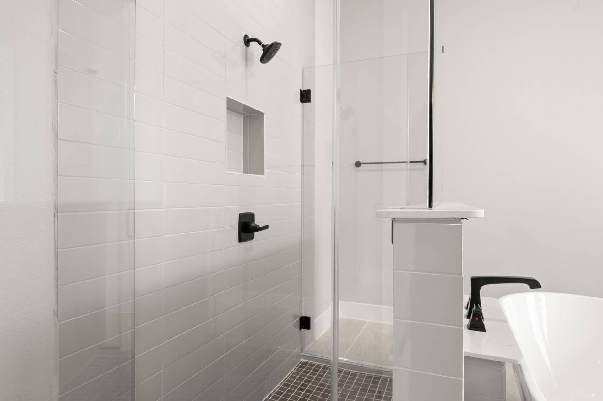 Modern bathroom with glass-enclosed shower and freestanding bathtub.