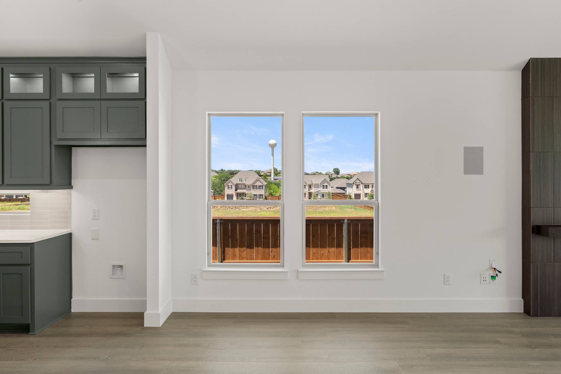 Modern dining area with large windows and dark cabinetry.
