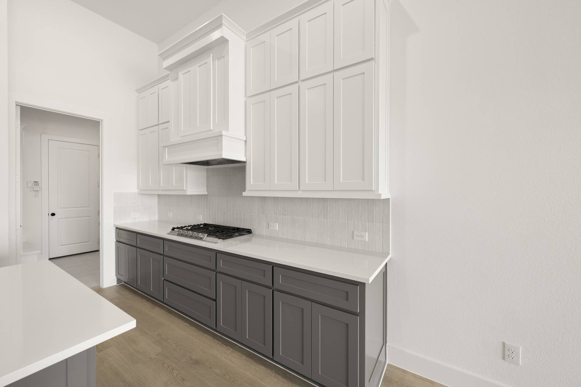Modern kitchen with white upper cabinets and dark lower cabinets.