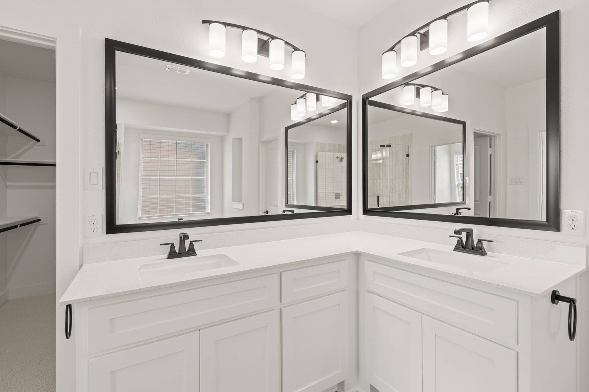 Modern bathroom with dual sinks, large mirrors, and stylish lighting fixtures.