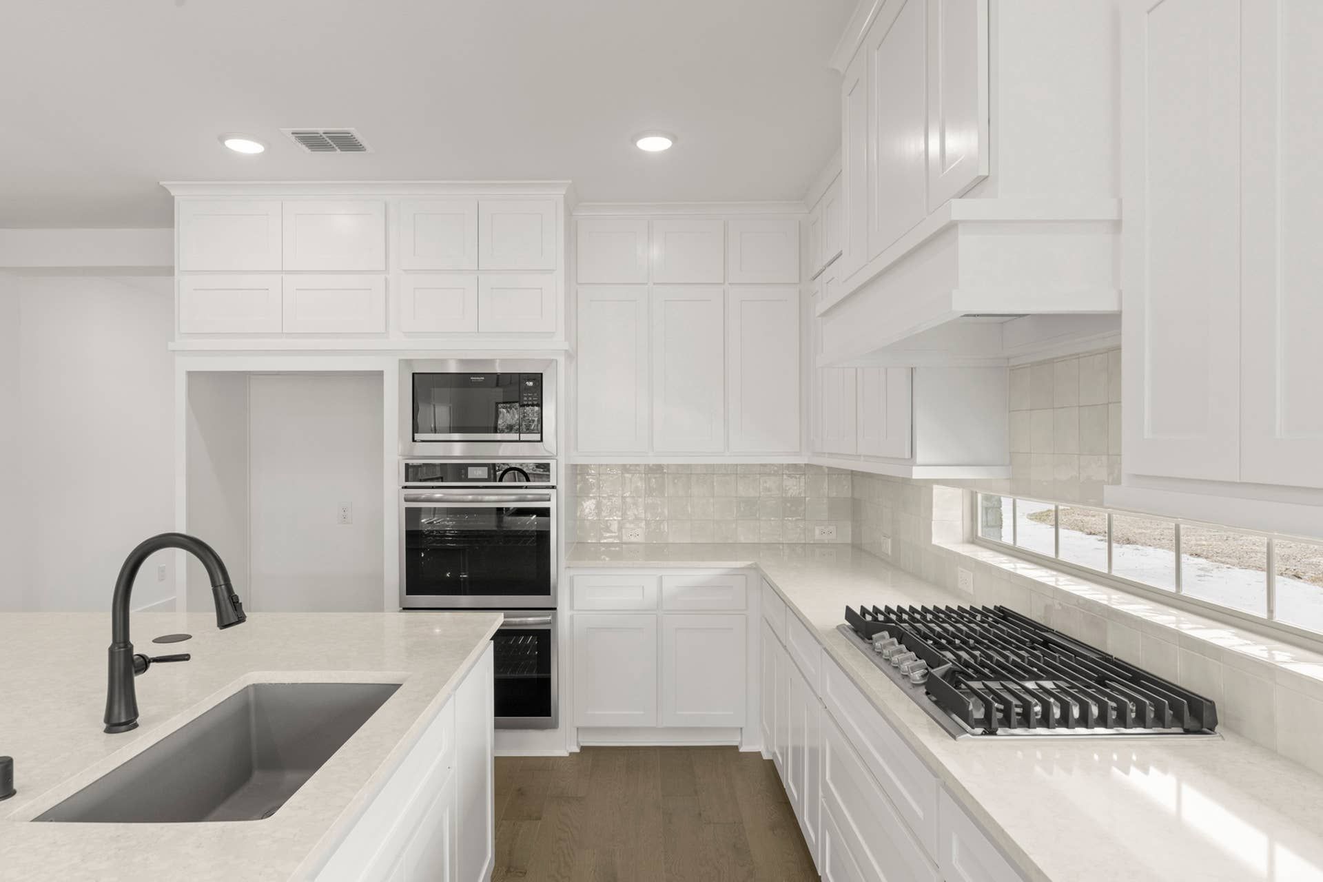 Modern kitchen with white cabinetry, sleek countertops, and built-in appliances.