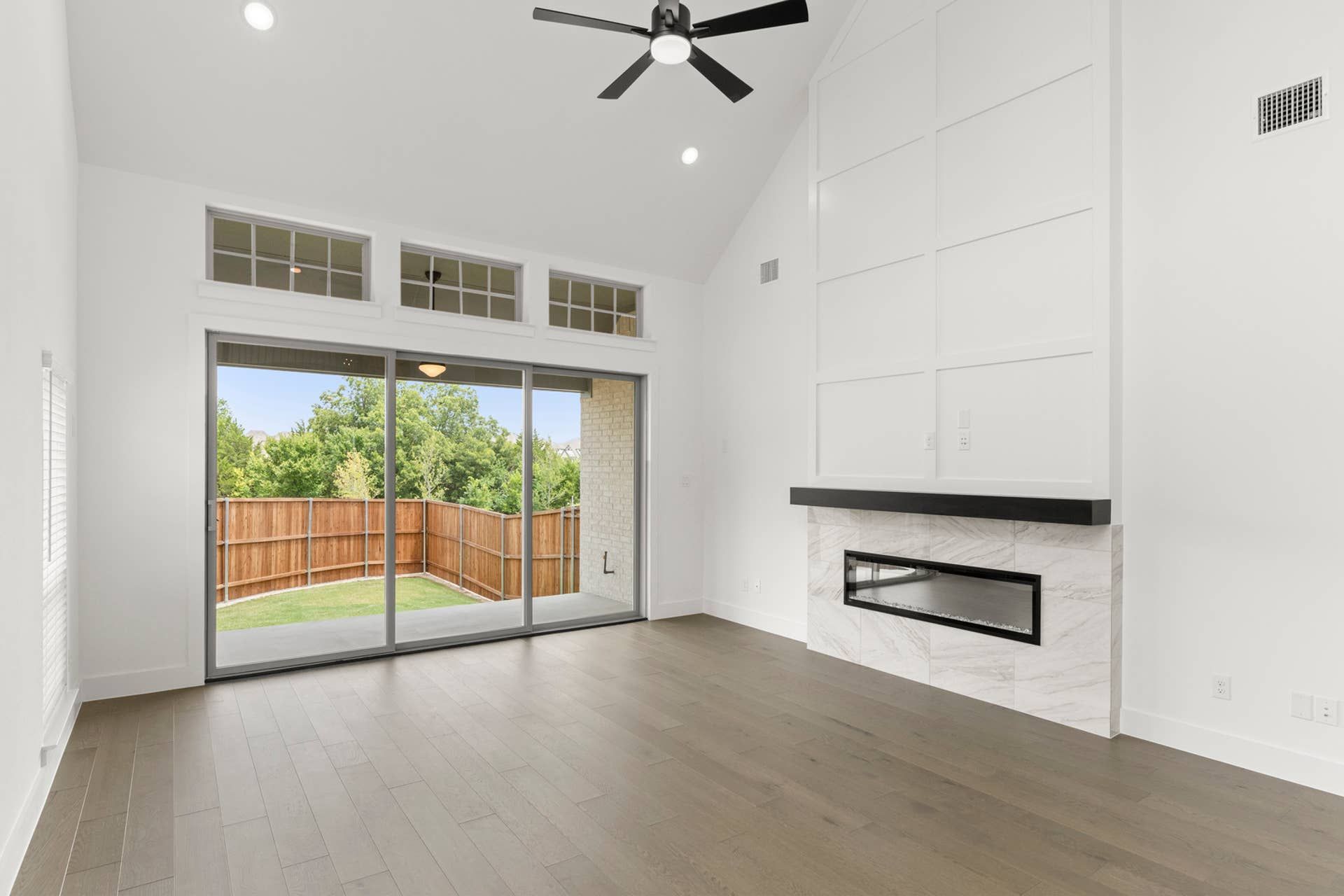Spacious living room with modern fireplace and large sliding glass doors to patio.
