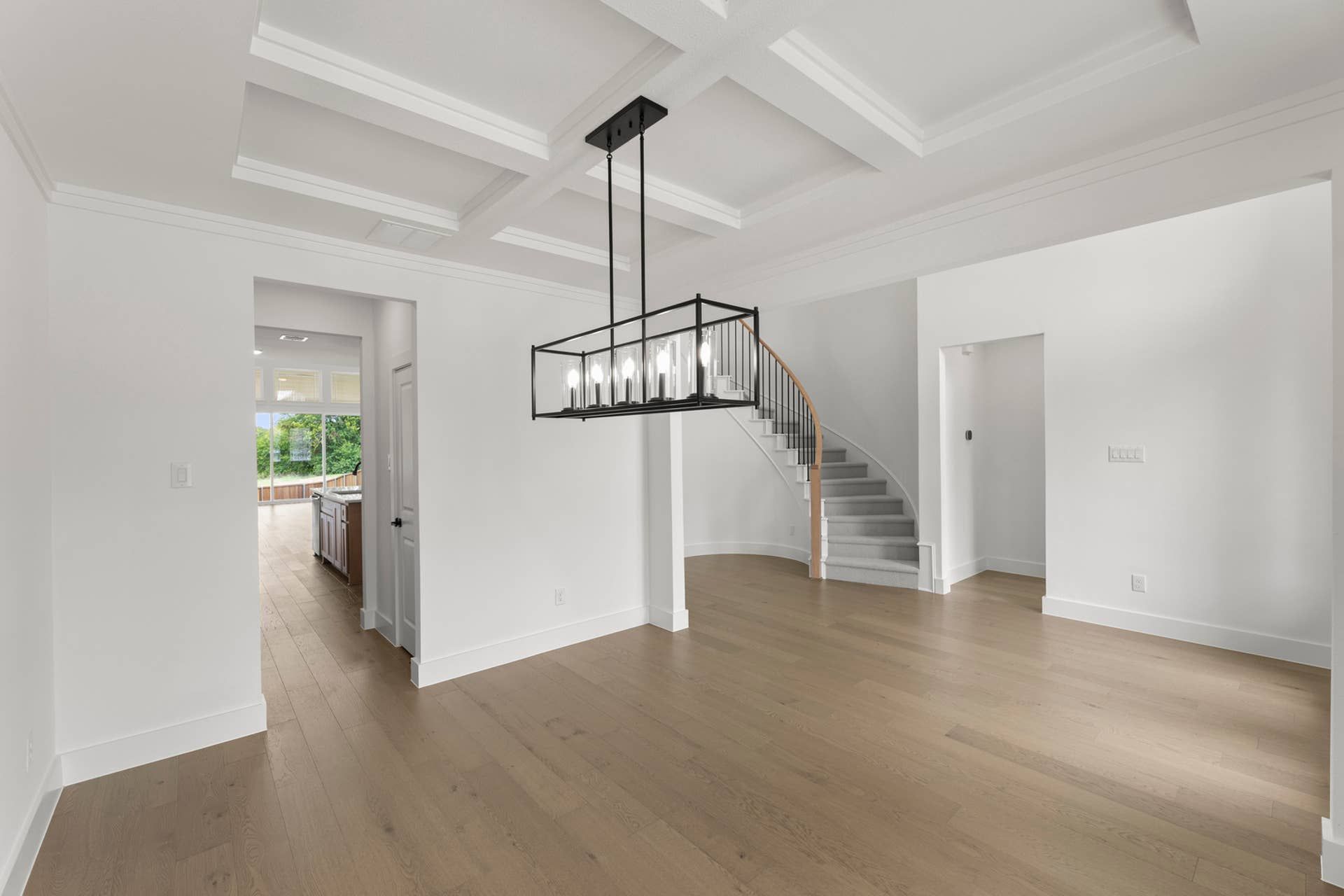 Elegant dining room with coffered ceiling and contemporary chandelier.
