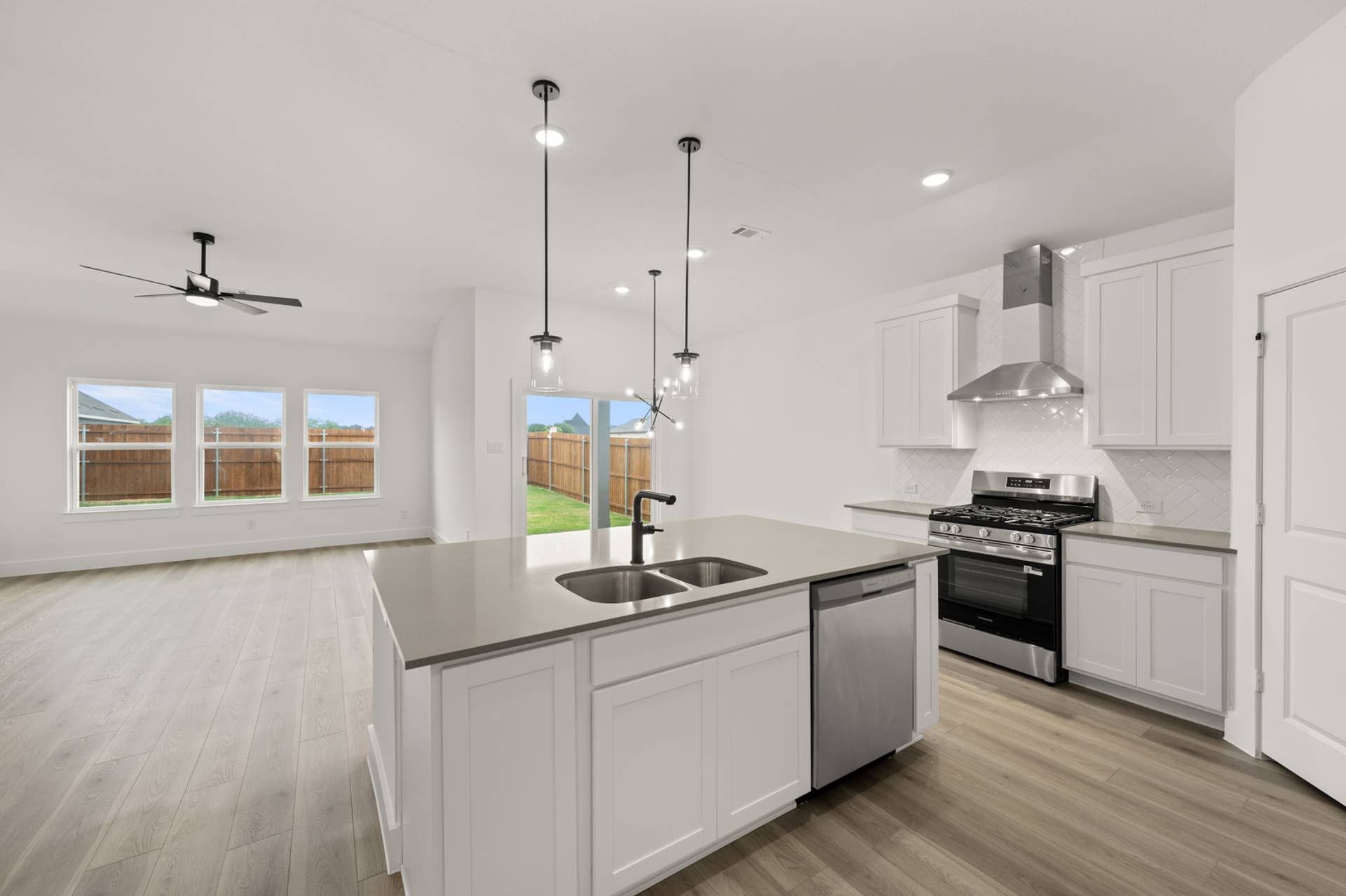 Modern kitchen with stainless steel appliances, island, and pendant lighting.