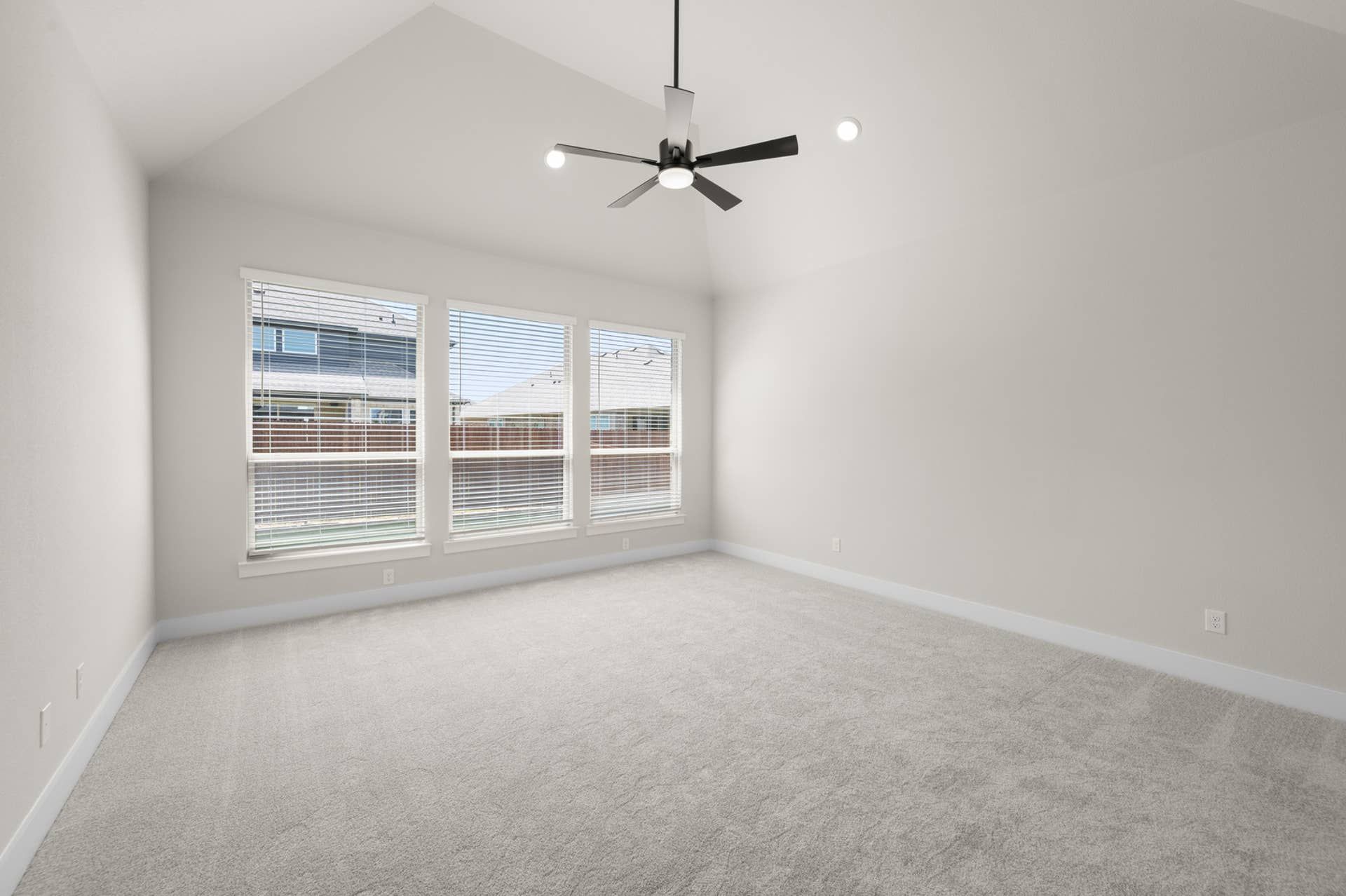 Spacious primary suite with vaulted ceiling and large windows.
