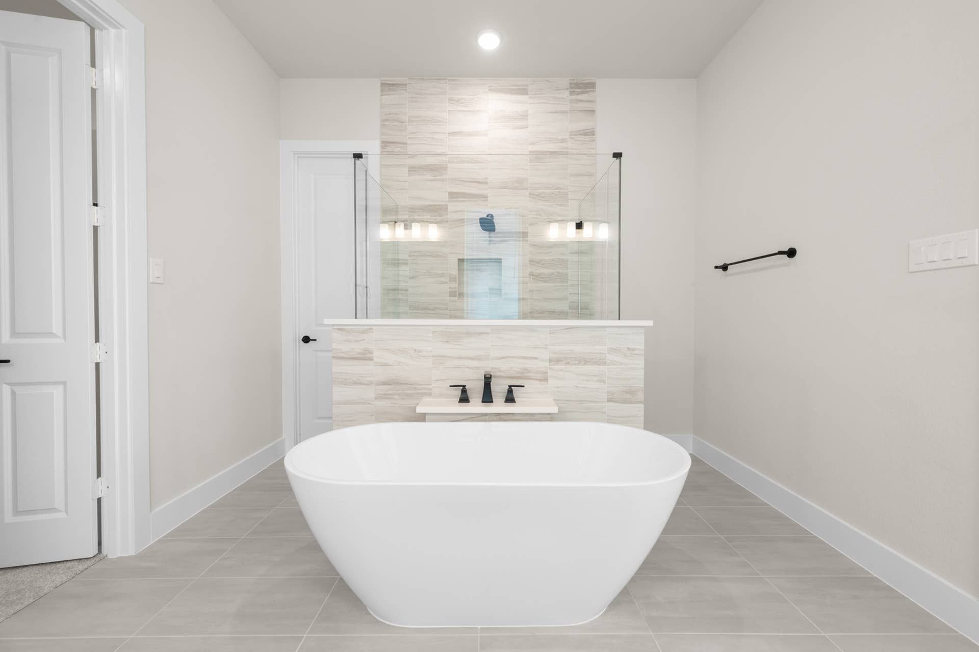 Modern bathroom with freestanding tub and glass-enclosed shower.