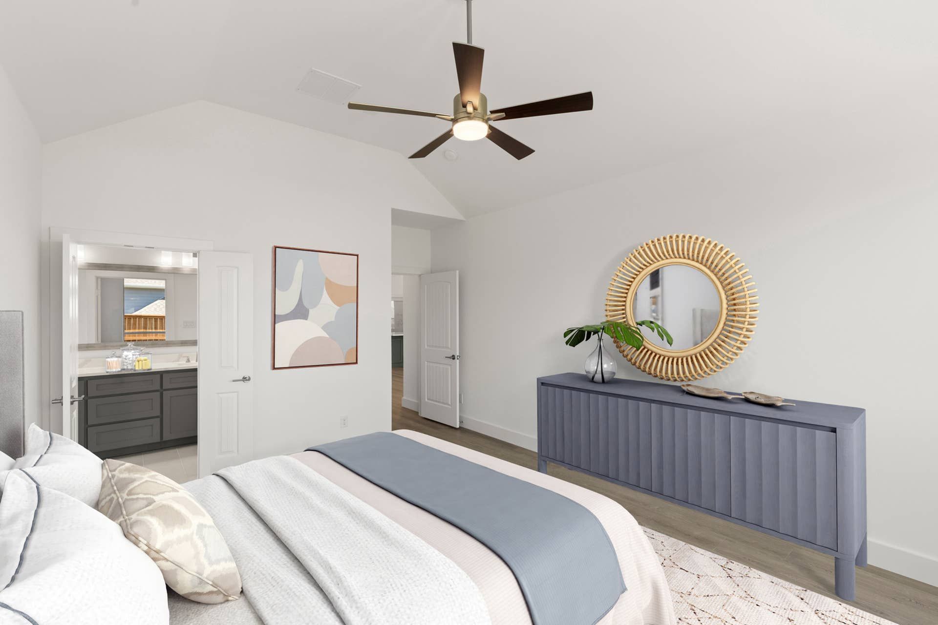 Modern bedroom with ceiling fan, stylish decor, and en-suite bathroom.