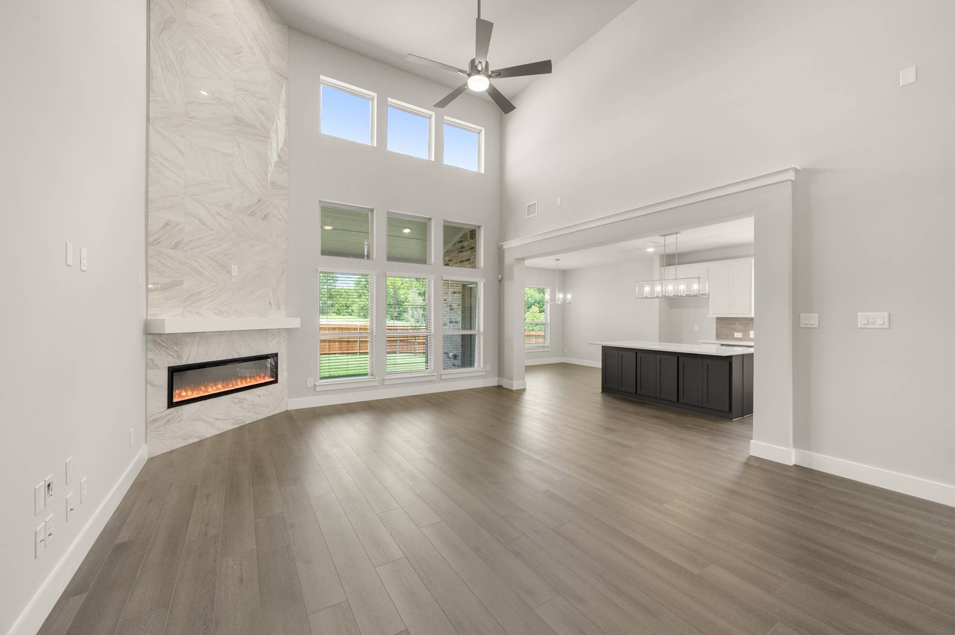 Spacious living room with high ceilings, modern fireplace, and large windows.