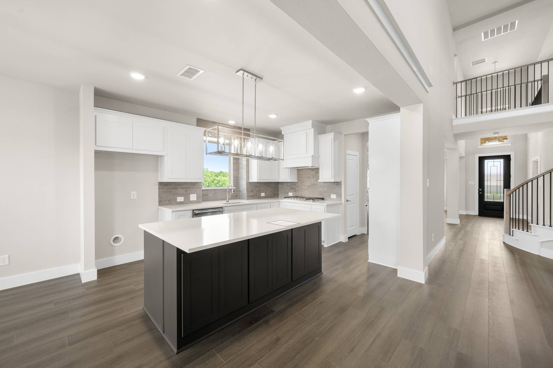 Modern kitchen with island, pendant lighting, and spacious open layout.