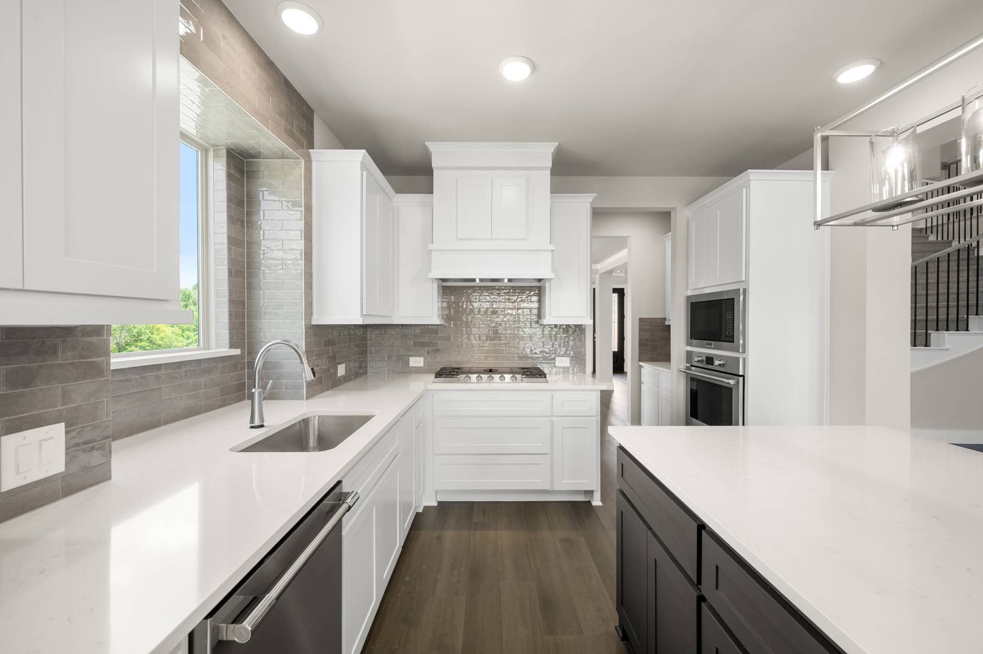 Modern kitchen with white cabinetry, stainless appliances, and large island.