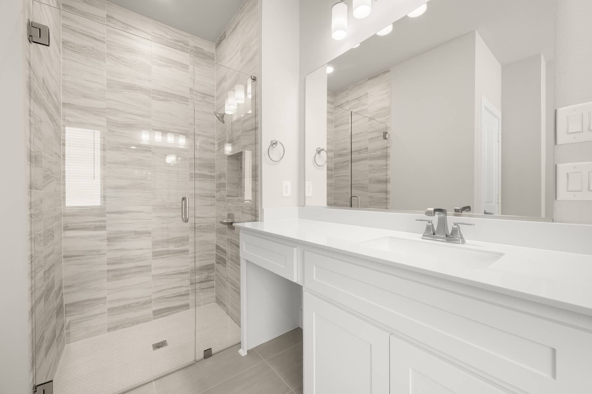 Elegant bathroom with glass shower and modern white vanity.