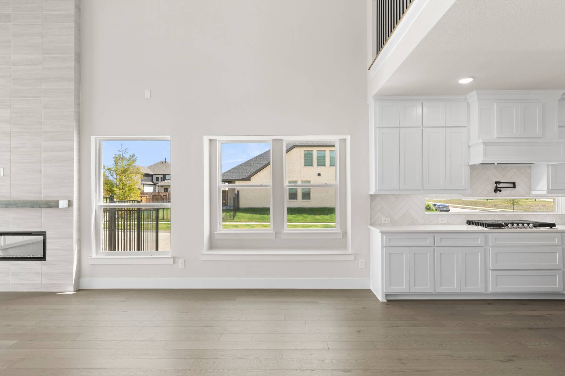 Modern dining area with large windows and white cabinetry.