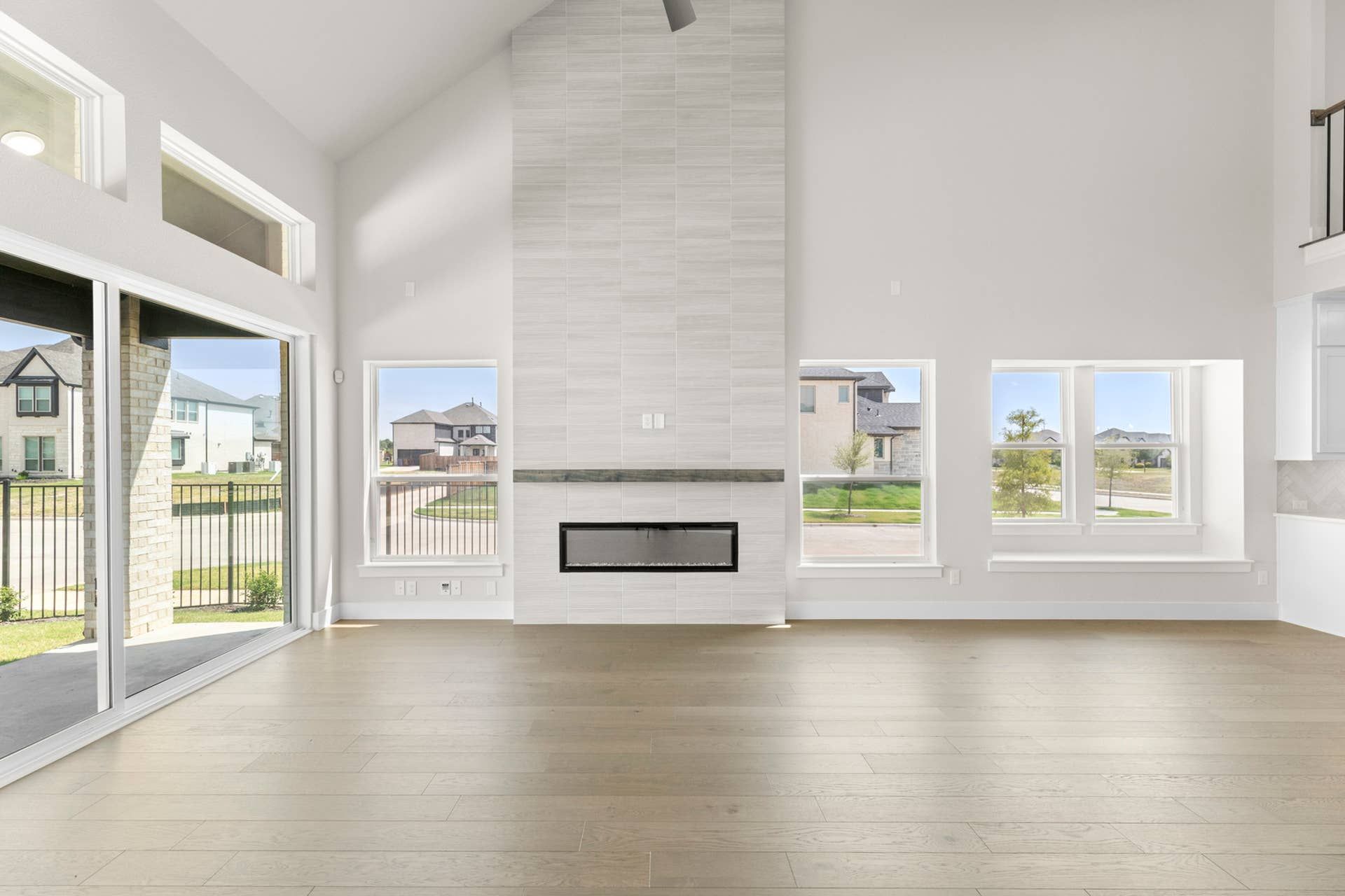 Spacious modern living room with large windows and sleek fireplace.