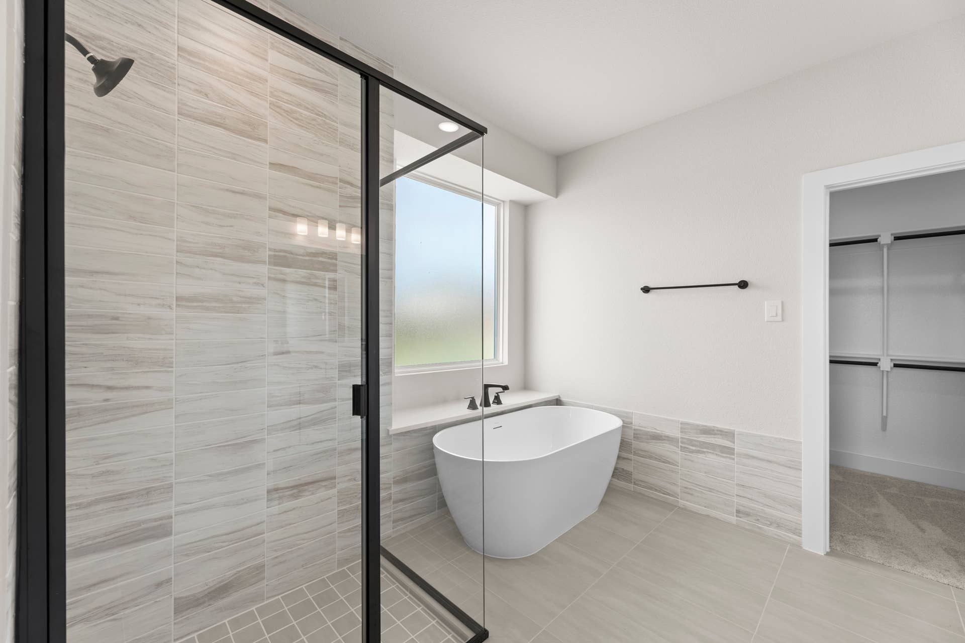 Modern bathroom with freestanding tub and glass-enclosed shower.