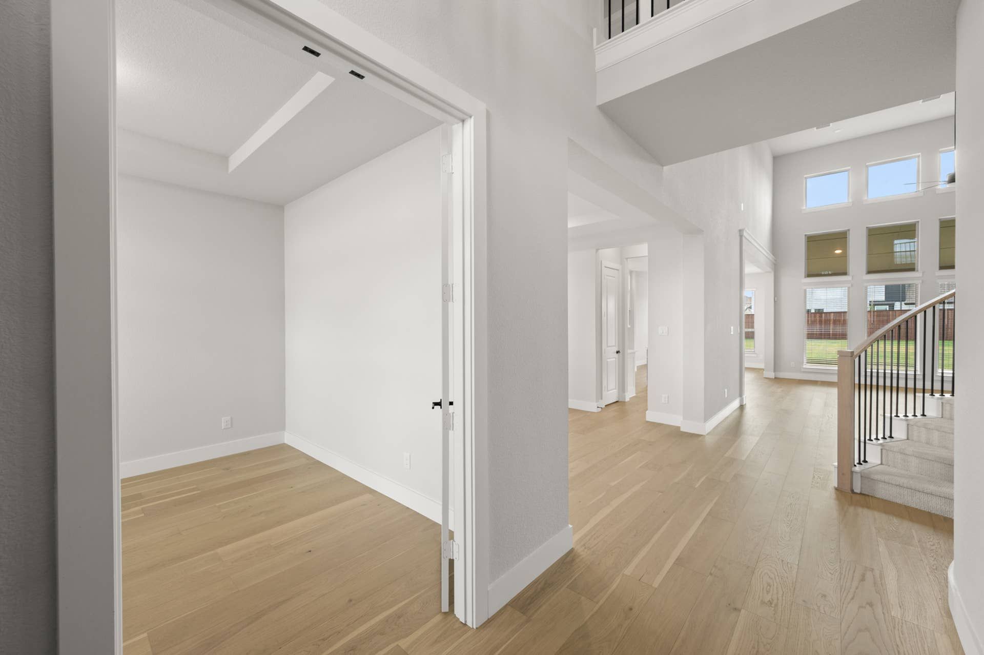 Spacious modern entryway with wooden floors and high ceilings.