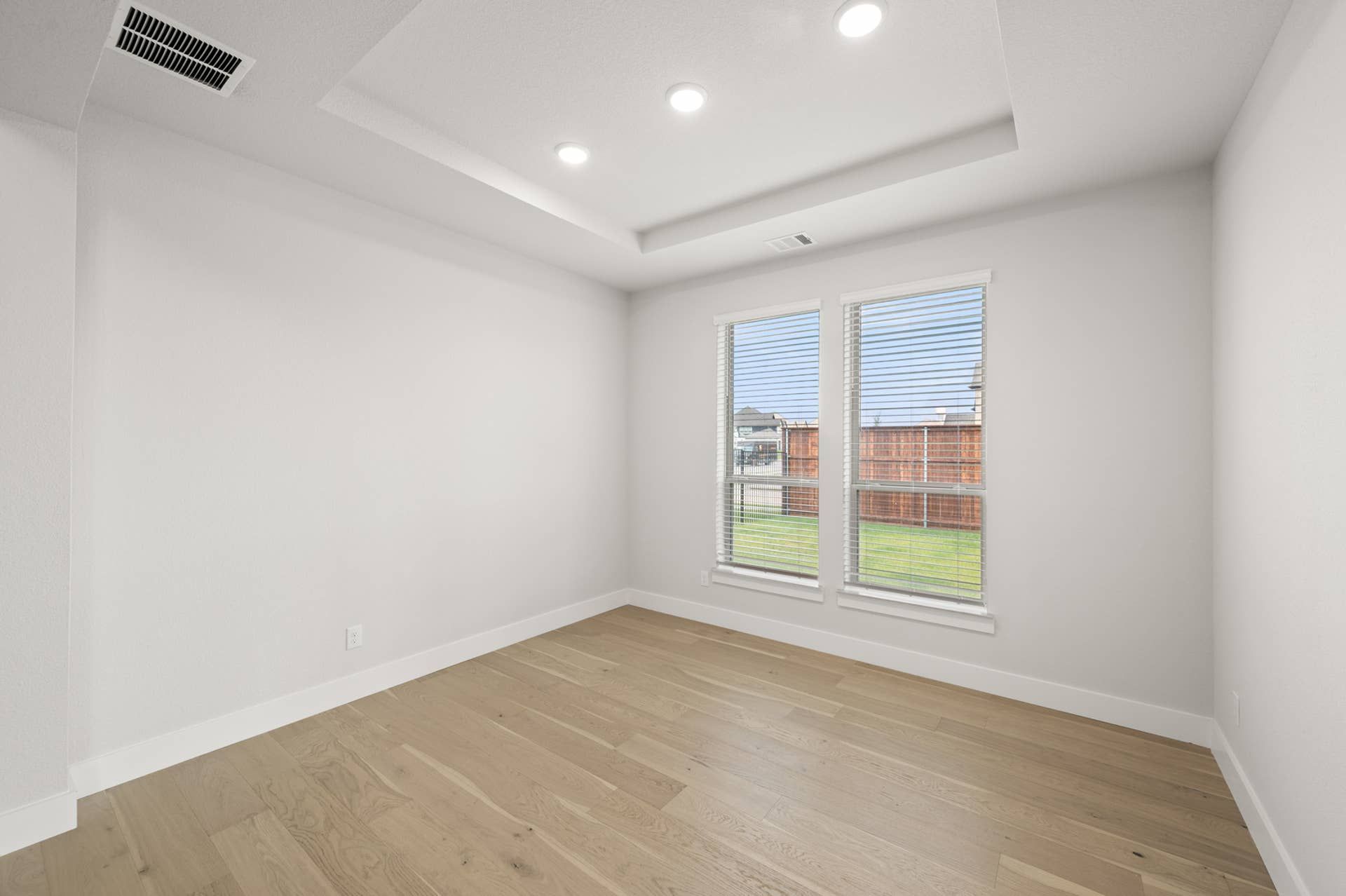 Bright flex space with recessed ceiling lights and large windows.