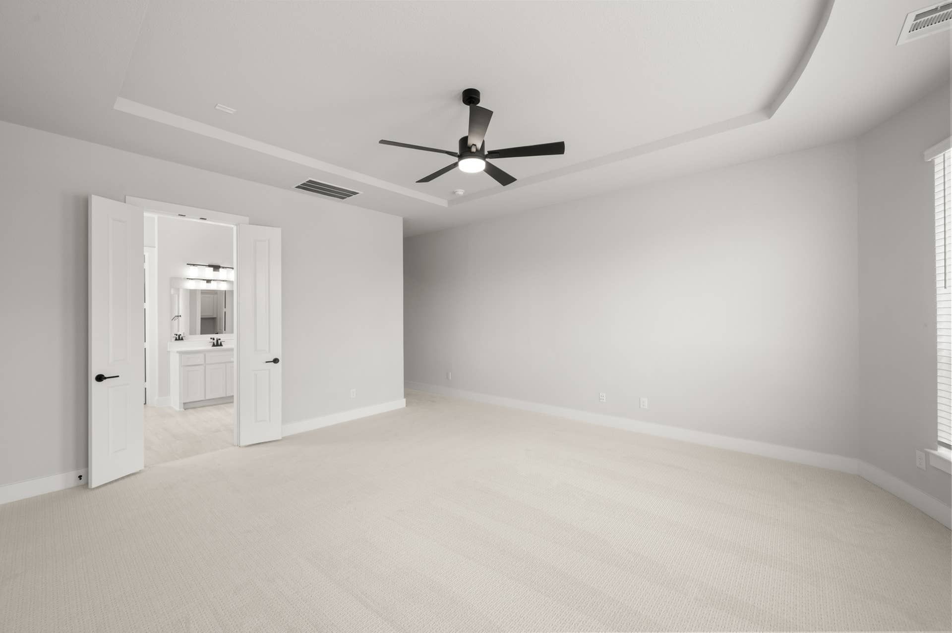 Spacious primary suite with ceiling fan and ensuite bathroom.