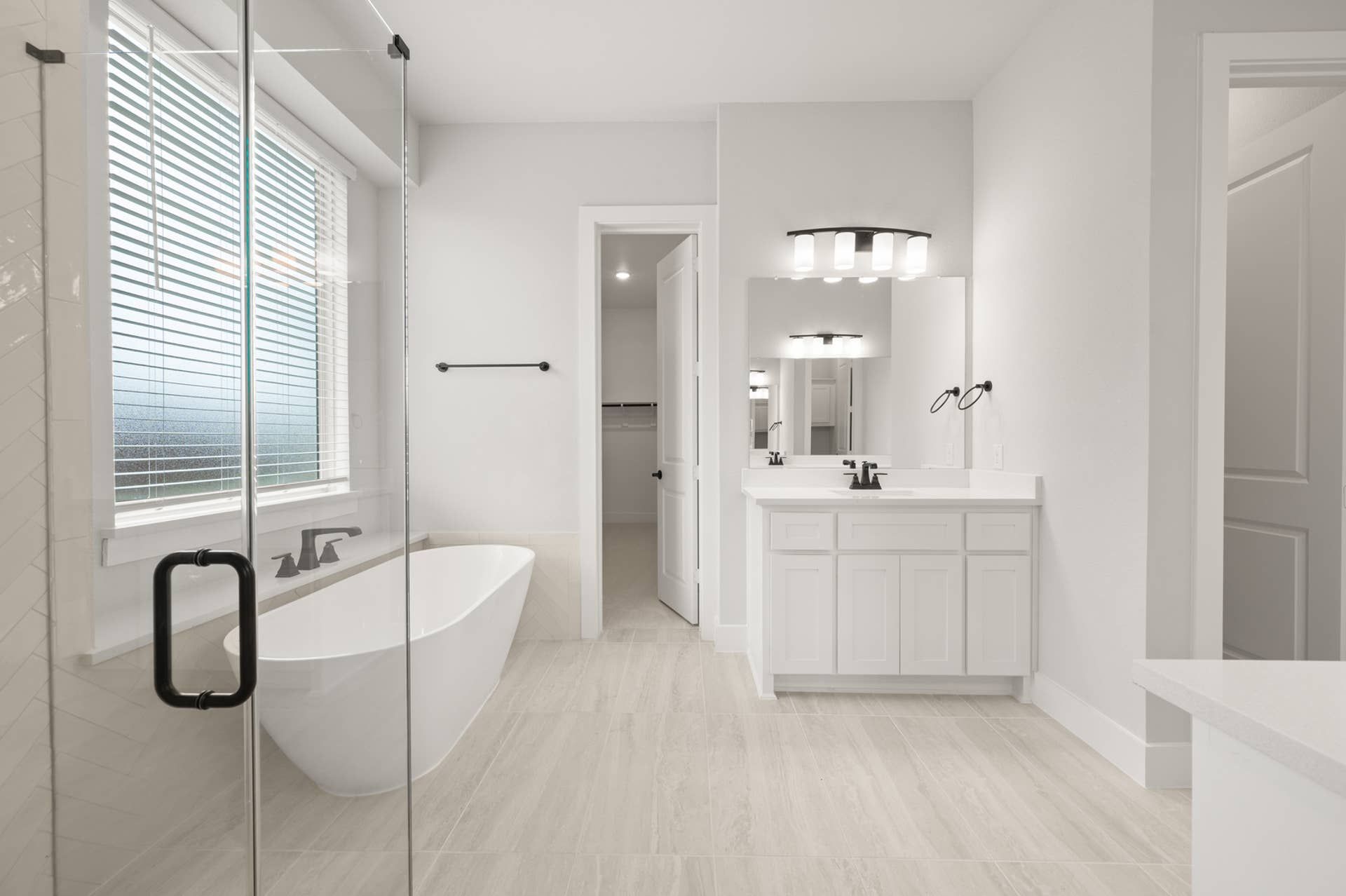 Modern bathroom with freestanding tub, double vanity, and glass shower enclosure.