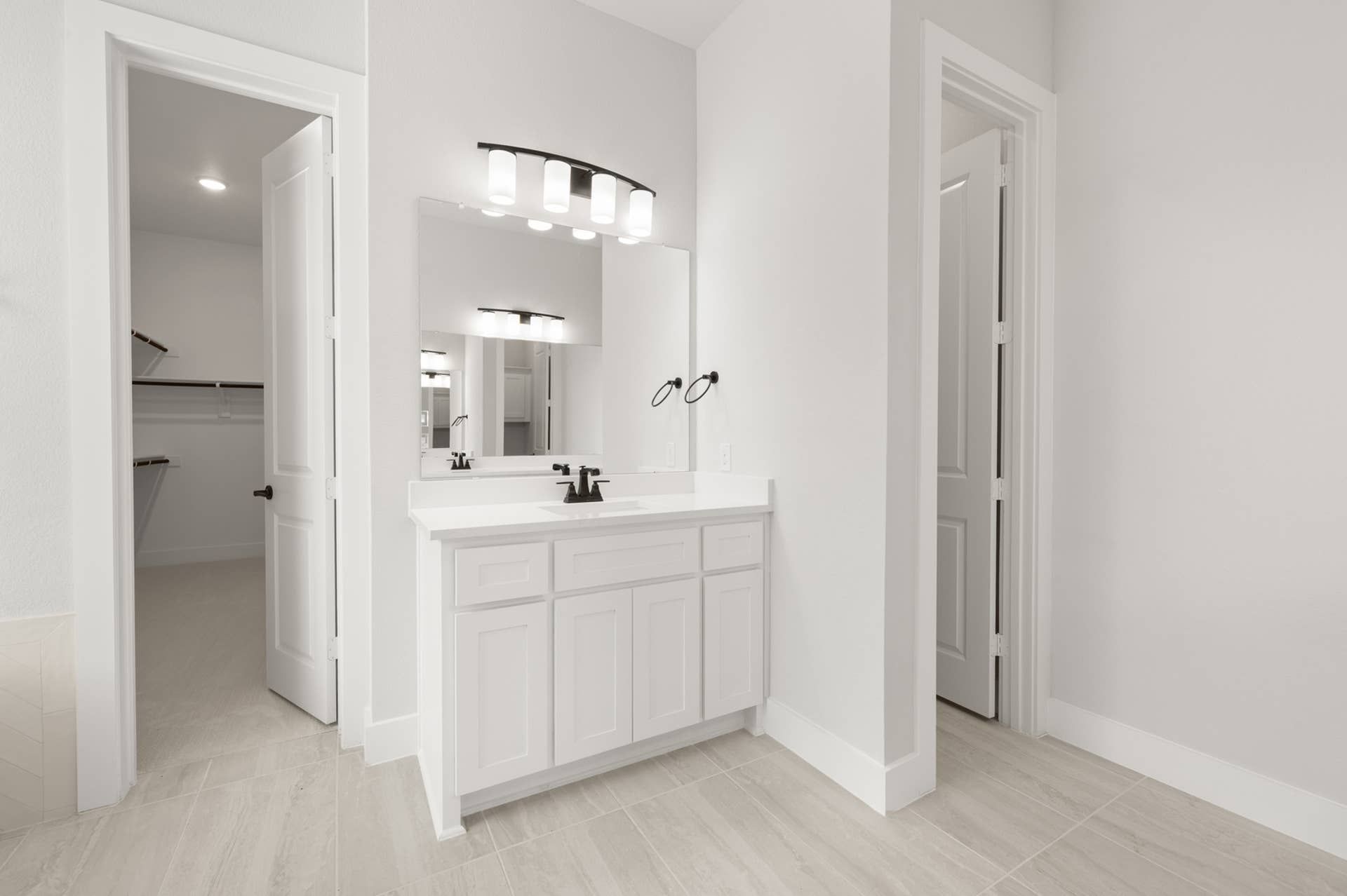 Primary bathroom suite with modern vanity and walk-in closet access.