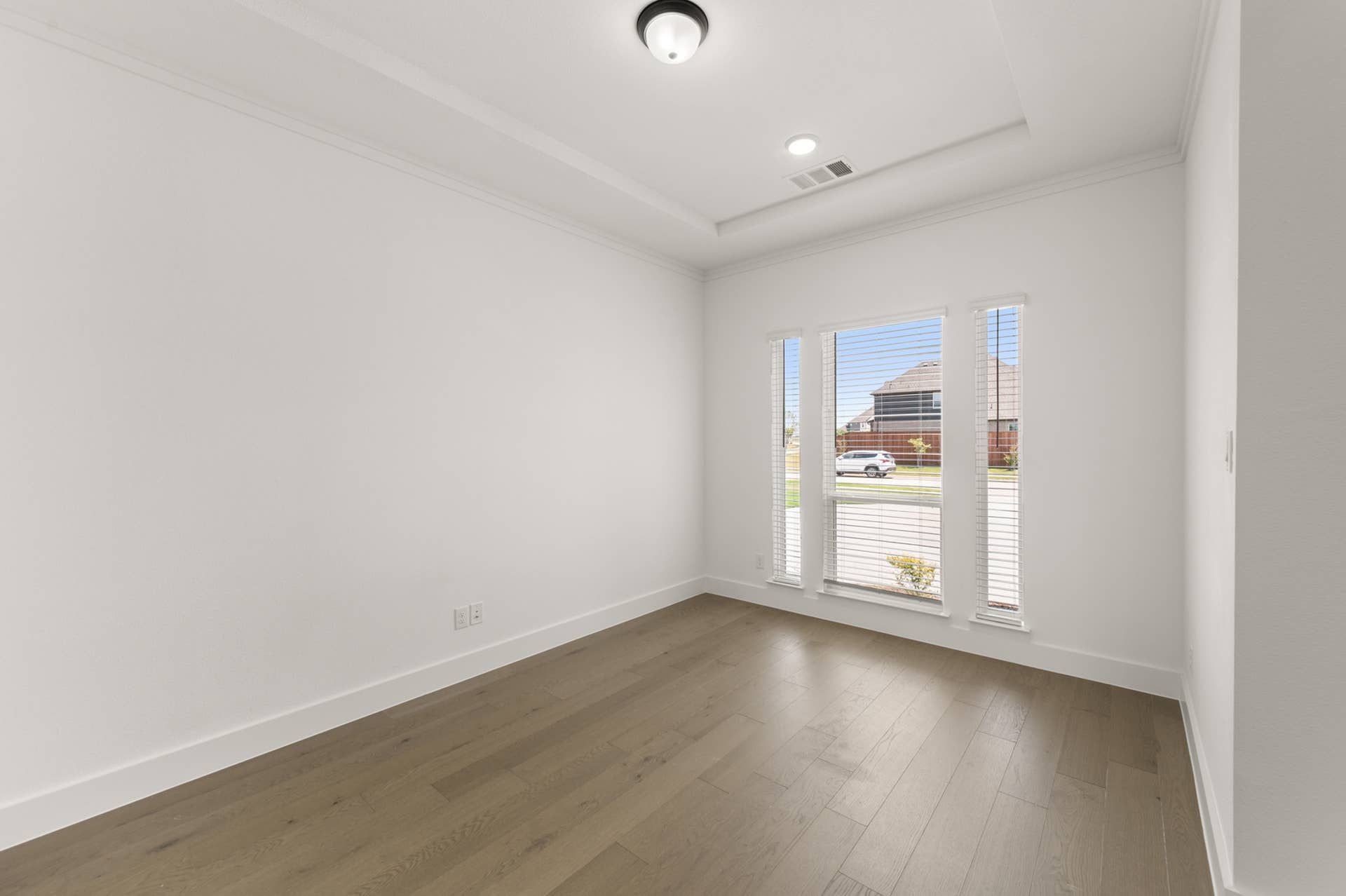 Bright flex space with hardwood floors and large windows for natural light.