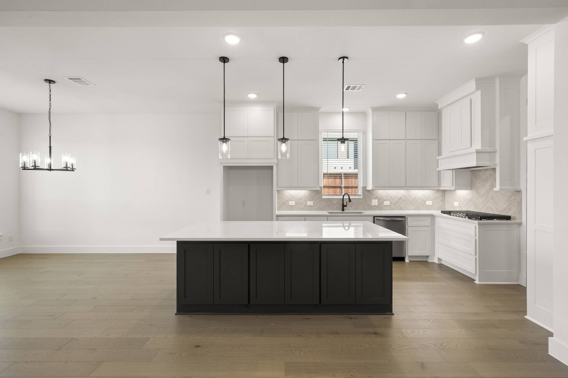 Spacious modern kitchen with large island and elegant pendant lighting.