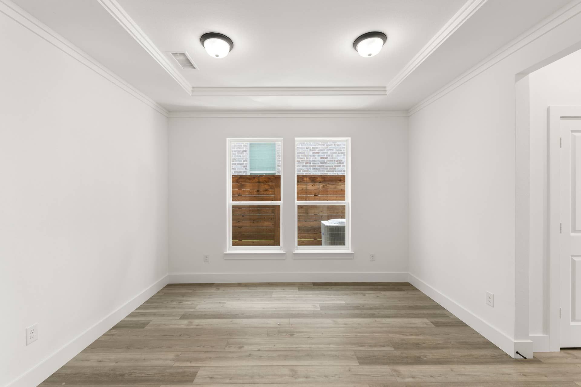 Bright dining room with wood flooring and crown molding.