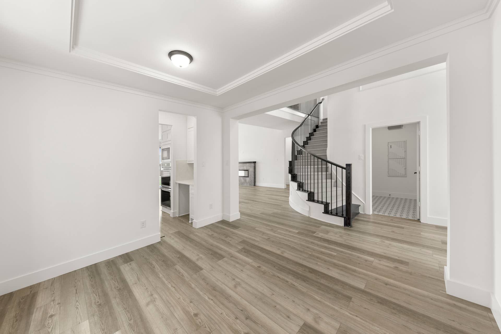 Spacious interior with elegant staircase and modern wood flooring.