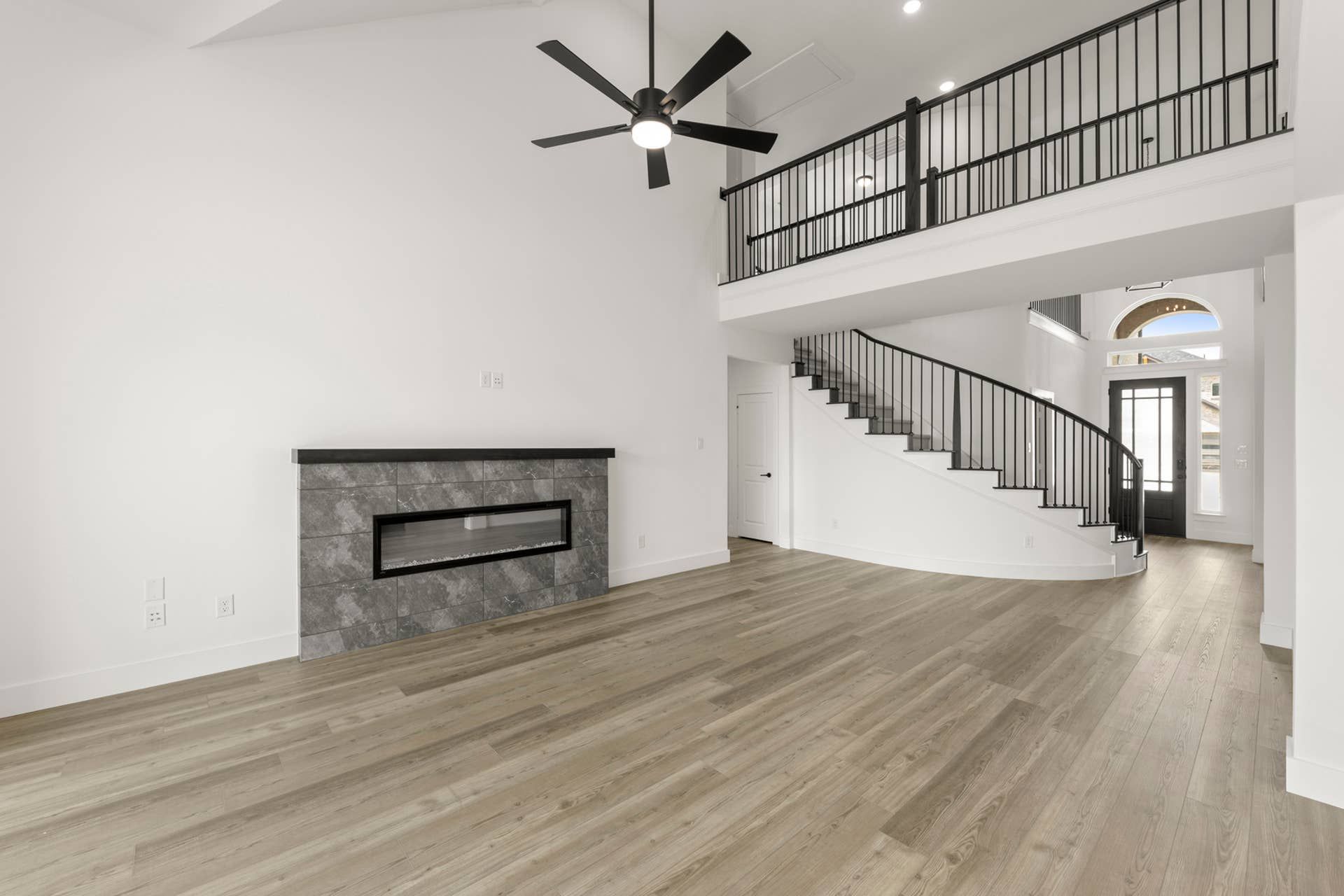 Spacious interior with modern fireplace and elegant curved staircase.