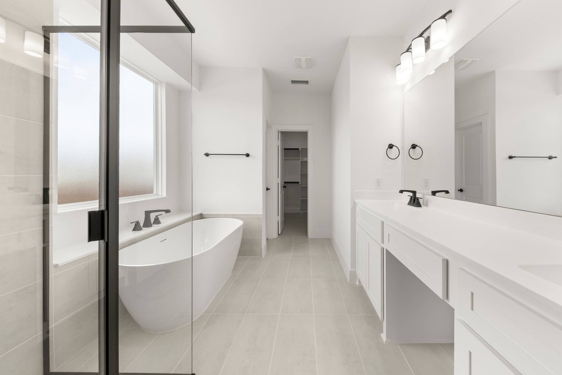 Modern bathroom with freestanding tub, glass shower, and dual-sink vanity.