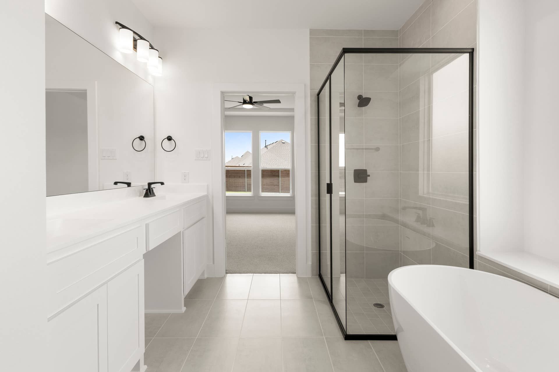 Modern bathroom with glass shower, freestanding tub, and double vanity.